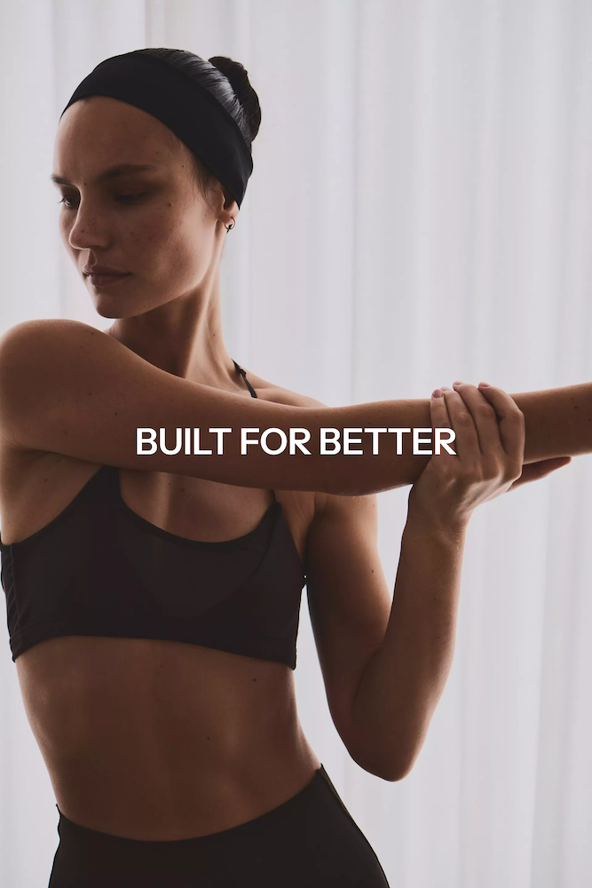 A woman with a headband on with gym kit with curtains in the background and 'Built for Better' as text overlay