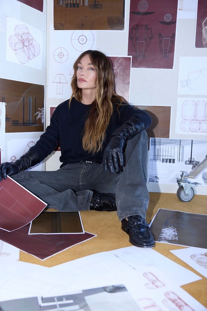 Woman sitting on the floor with moodboard around her. The person is Kelly Wearstler