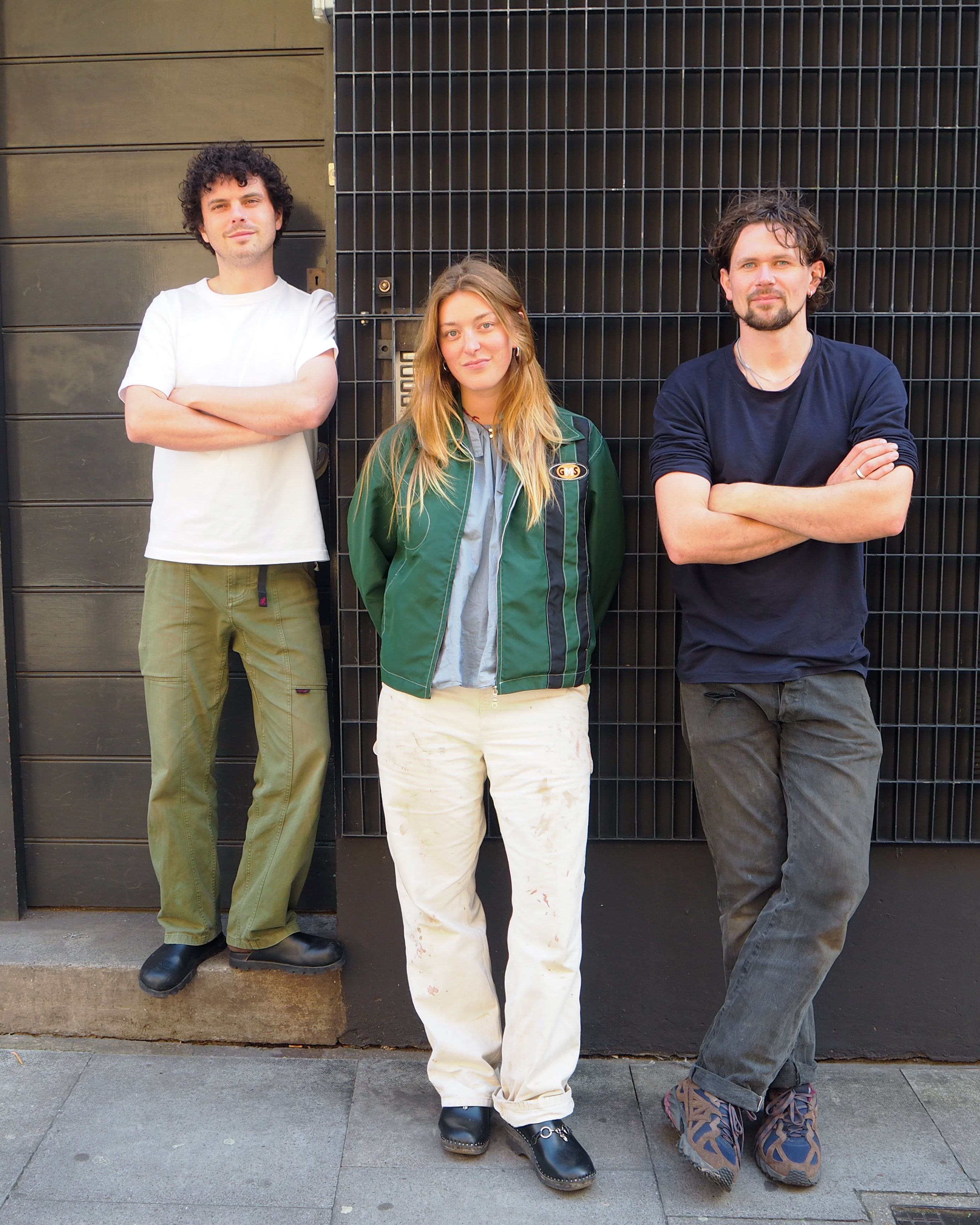 Three members of Mitre & Mondays against a wall