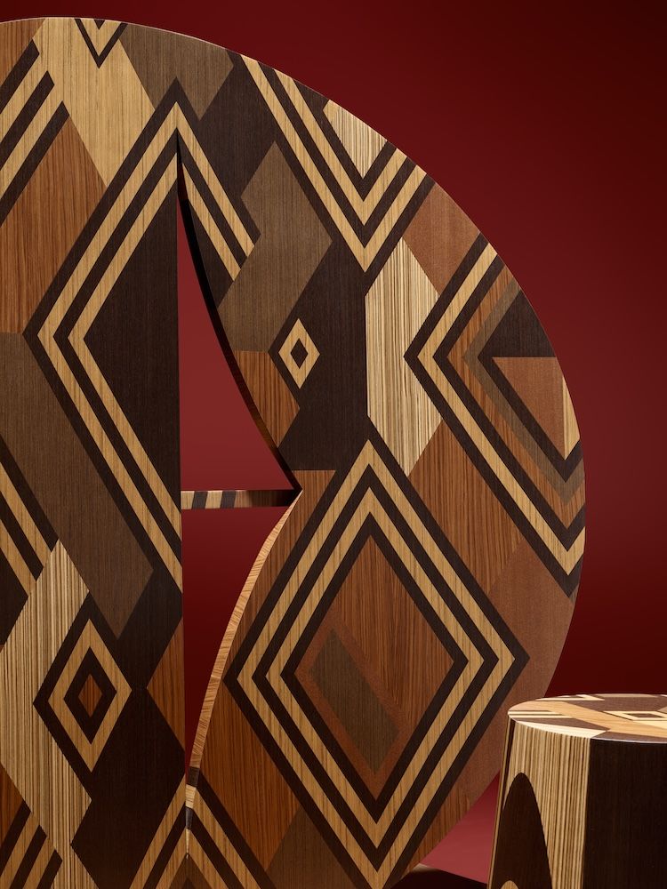 Patterned marquetry in black and brown against a red backdrop by Stehen Burks and ALPI