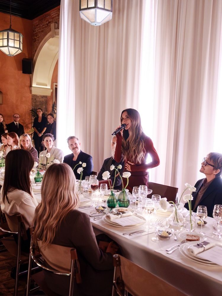 Woman standing making a speech at dinner, Victoria Beckham
