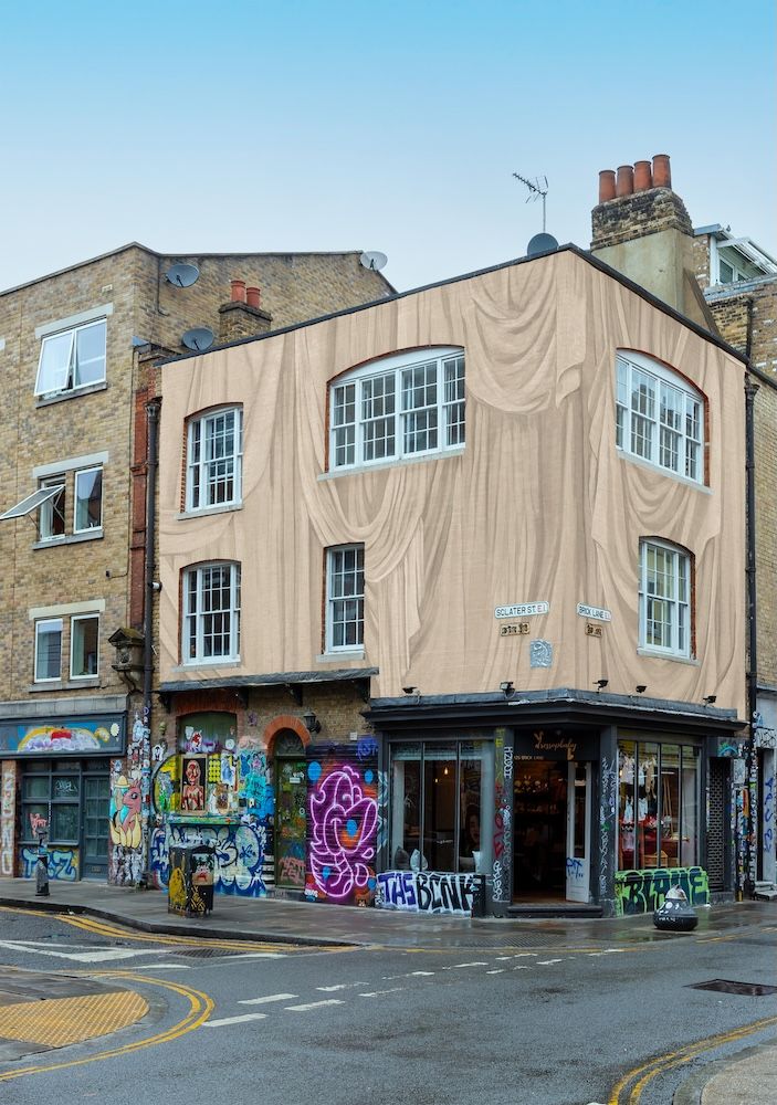 A street in London with graffiti on the stree t with building wrapped in Calico Wallpaper x Lee Broom designed wrapping building