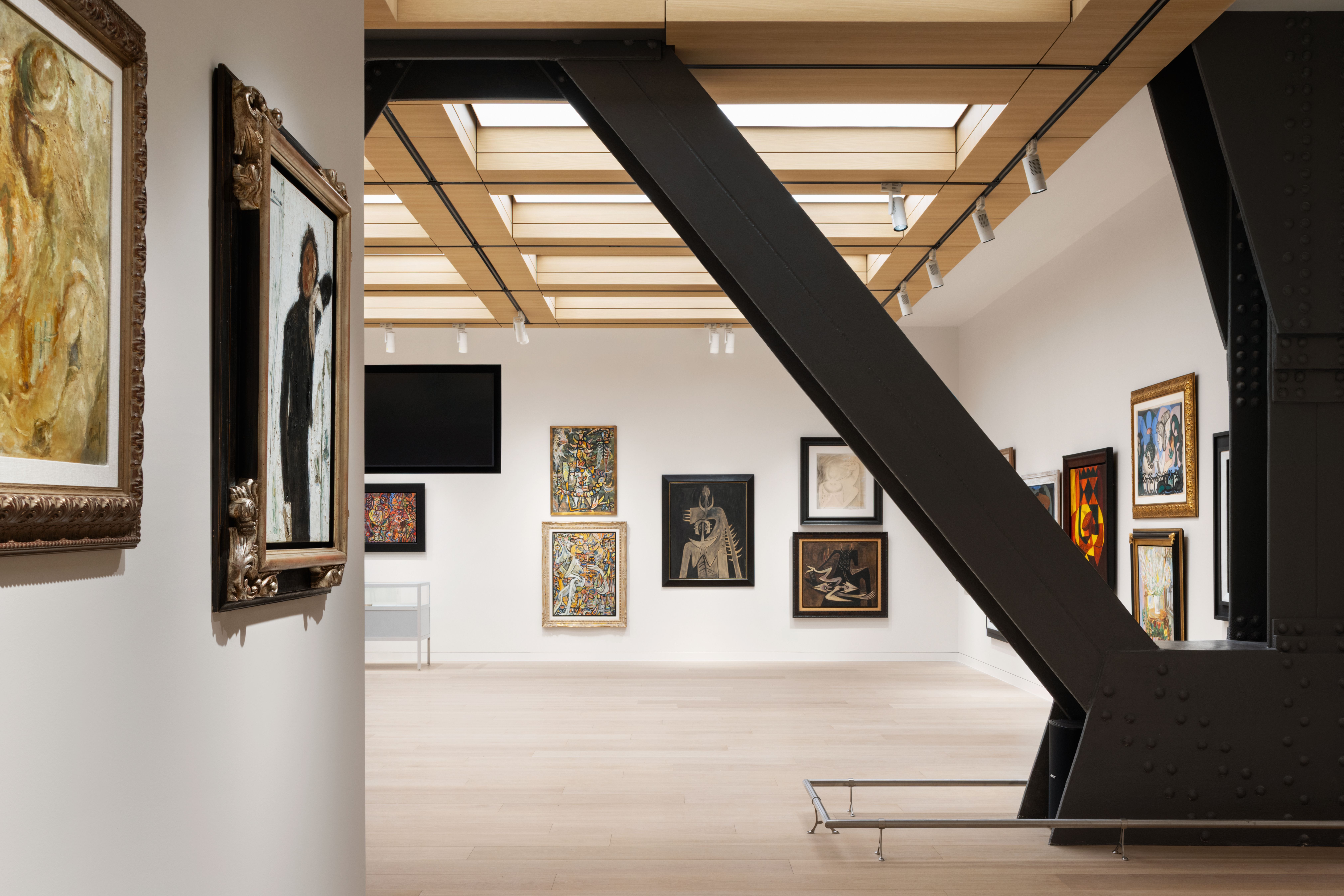 Inside a gallery of white walls with artworks hanging in the space