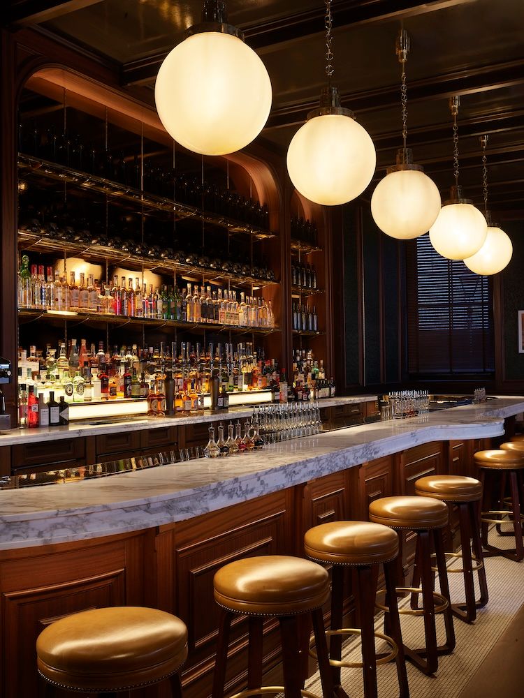 Bar with stools and overhead lighting and marble top