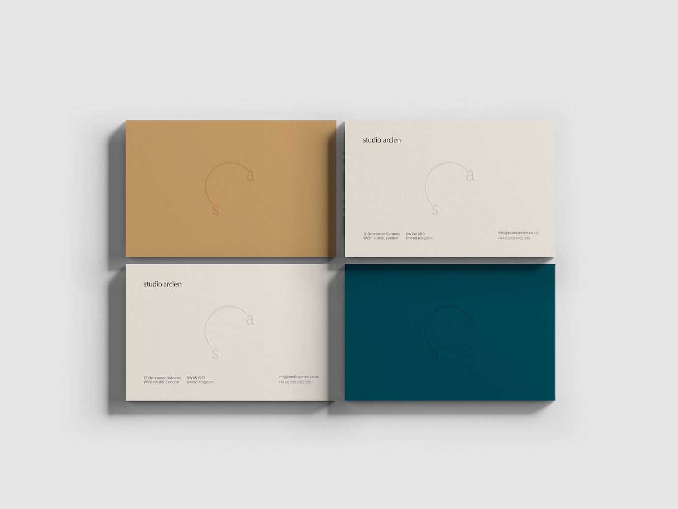 Four business cards in mustard. blue, cream and blue with writing on them 