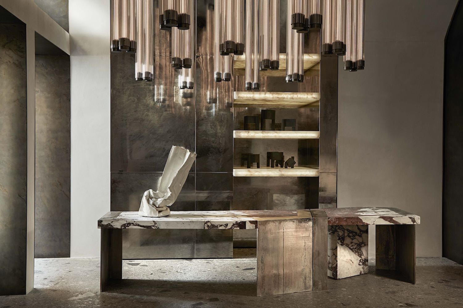 Interior set up in brass bronze and gold with lighting, tables and sculpture