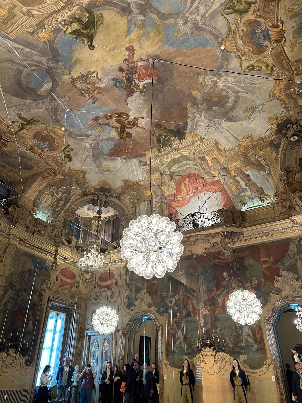 Ceiling with classical paintings and a modern pendant light.
