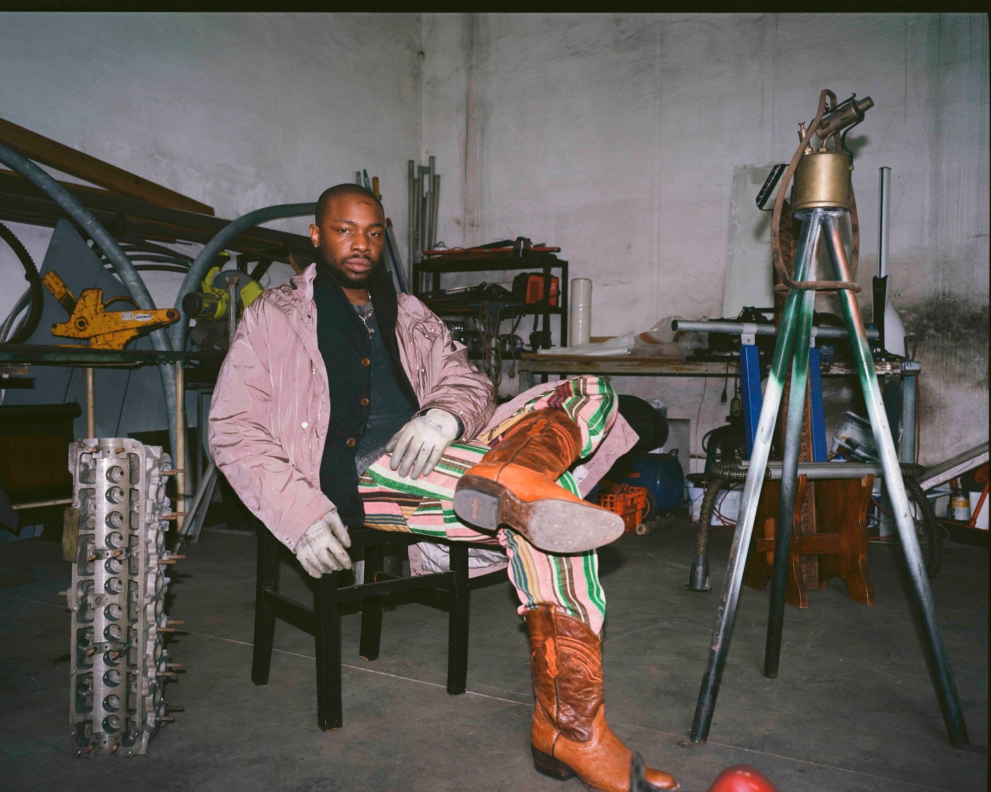 Artist Dozie Kanu sitting on chair in his studio 