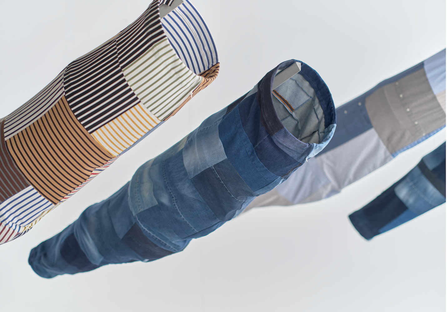 Tubes of patchwork fabric in different shades of blue and stripe