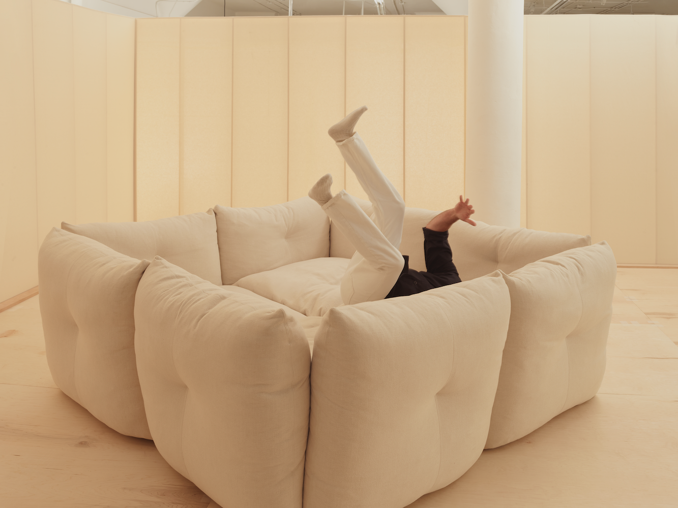 Willo Perron diving into his designed sofa for Knoll in beige tone