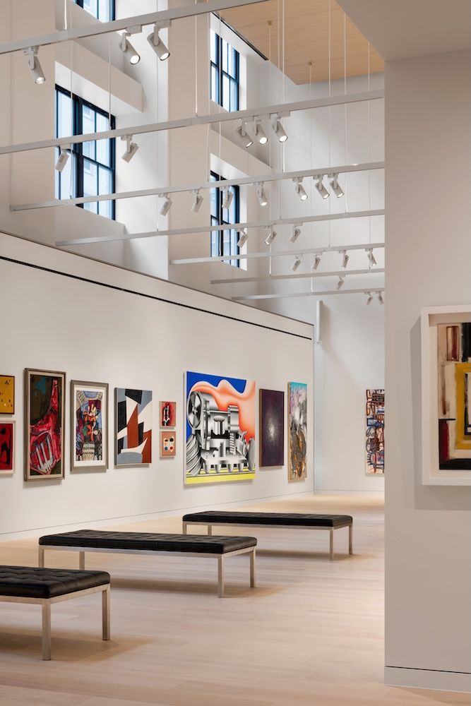 Three benches in a row with artworks on display in light filled high ceiling room