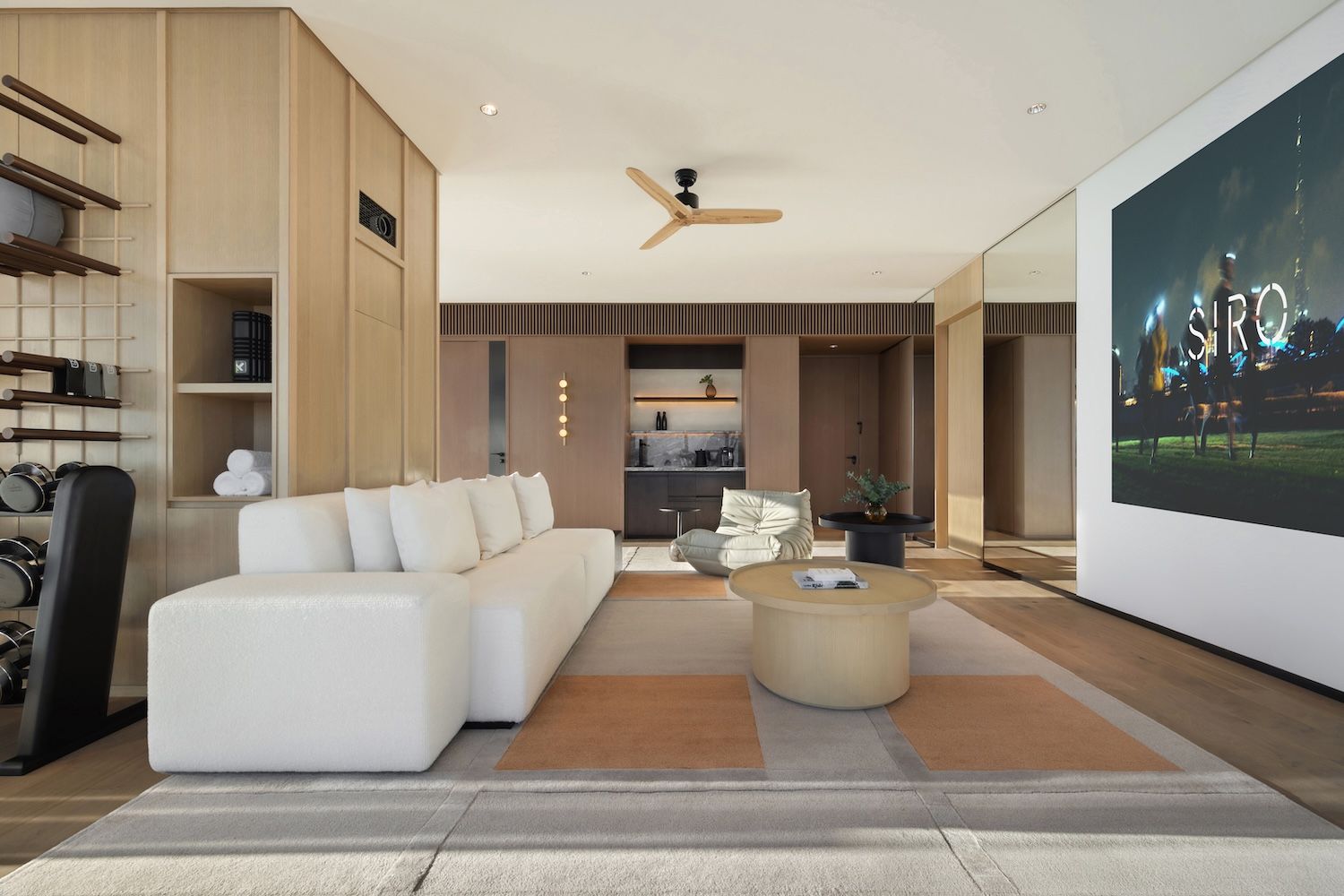 A set up of a hotel room with Siro on the screen in writing on the right and a fan on the ceiling and white sofa 
