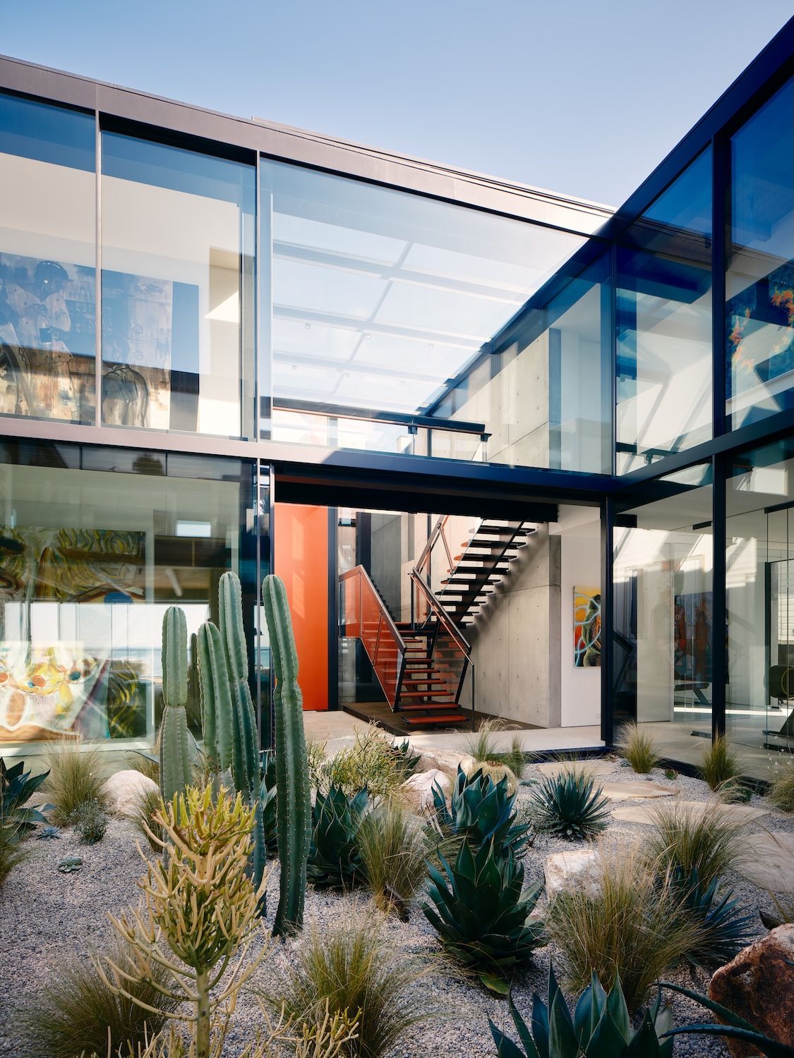Facade of Carbon House by Olson Kundig with cactus in the foreground and glass structure