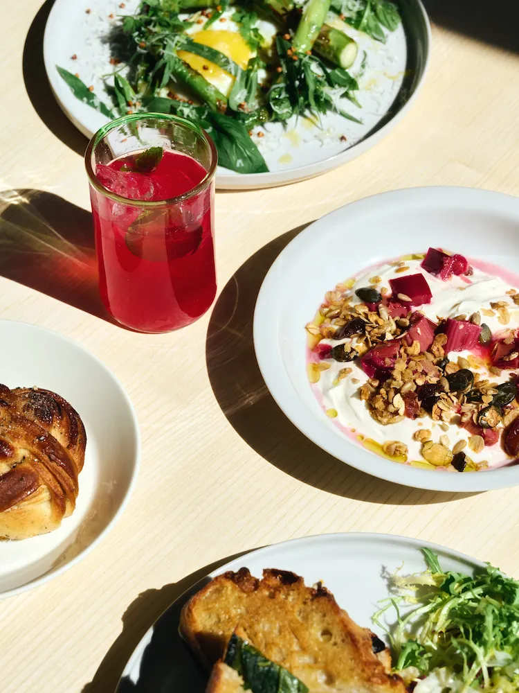 Food and a red drink displayed on a table in three different plates