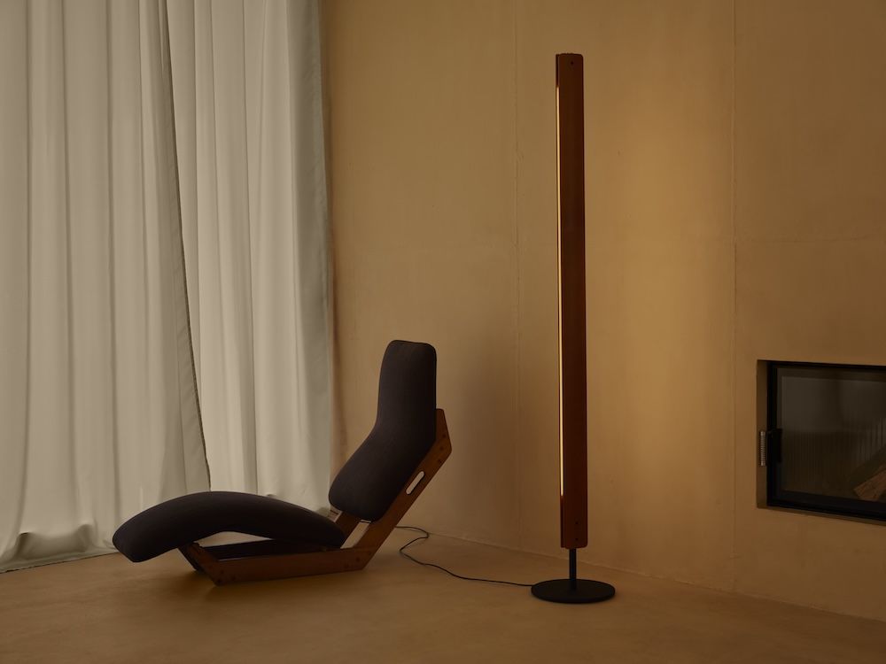 Illuminated Flos lamp beside a modern lounge chair