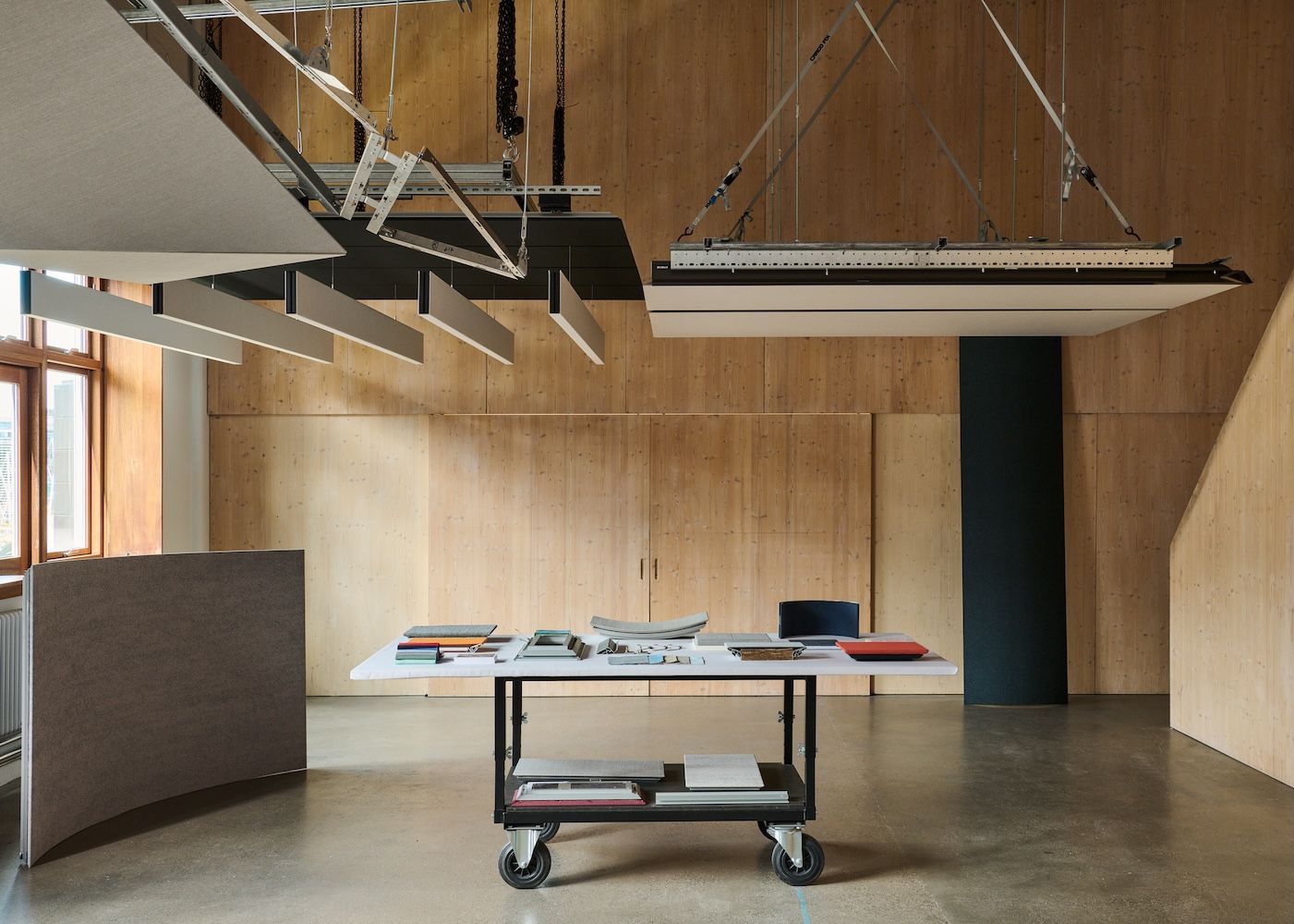 Office set up with table and overhead lighting and wooden walls