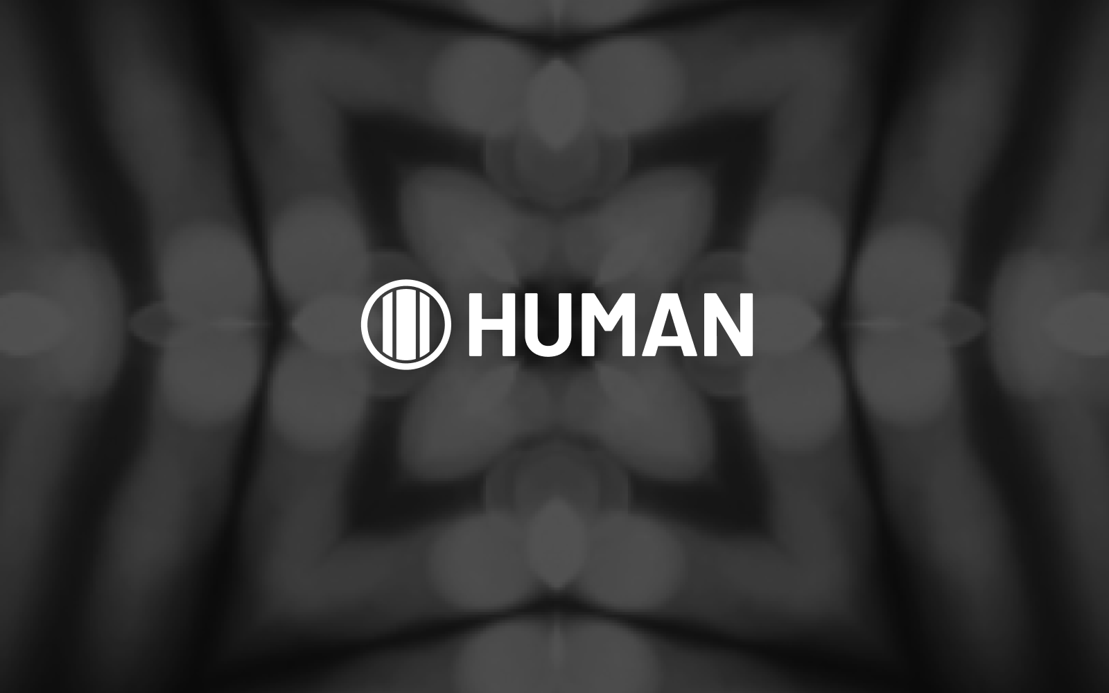 White 'HUMAN' text and logo (a circle with three vertical lines) on a dark, blurred, symmetrical background with bokeh lights.