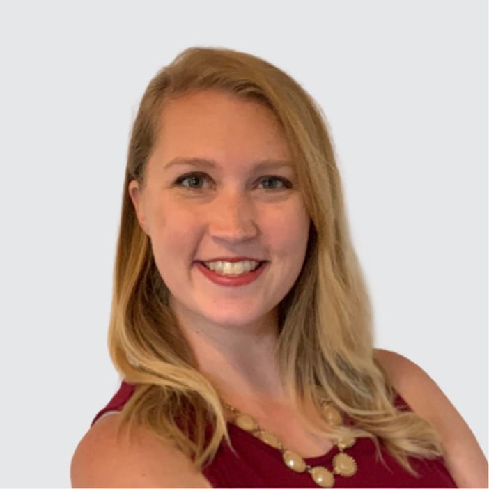 Headshot of a smiling woman with blonde hair in a red top.
