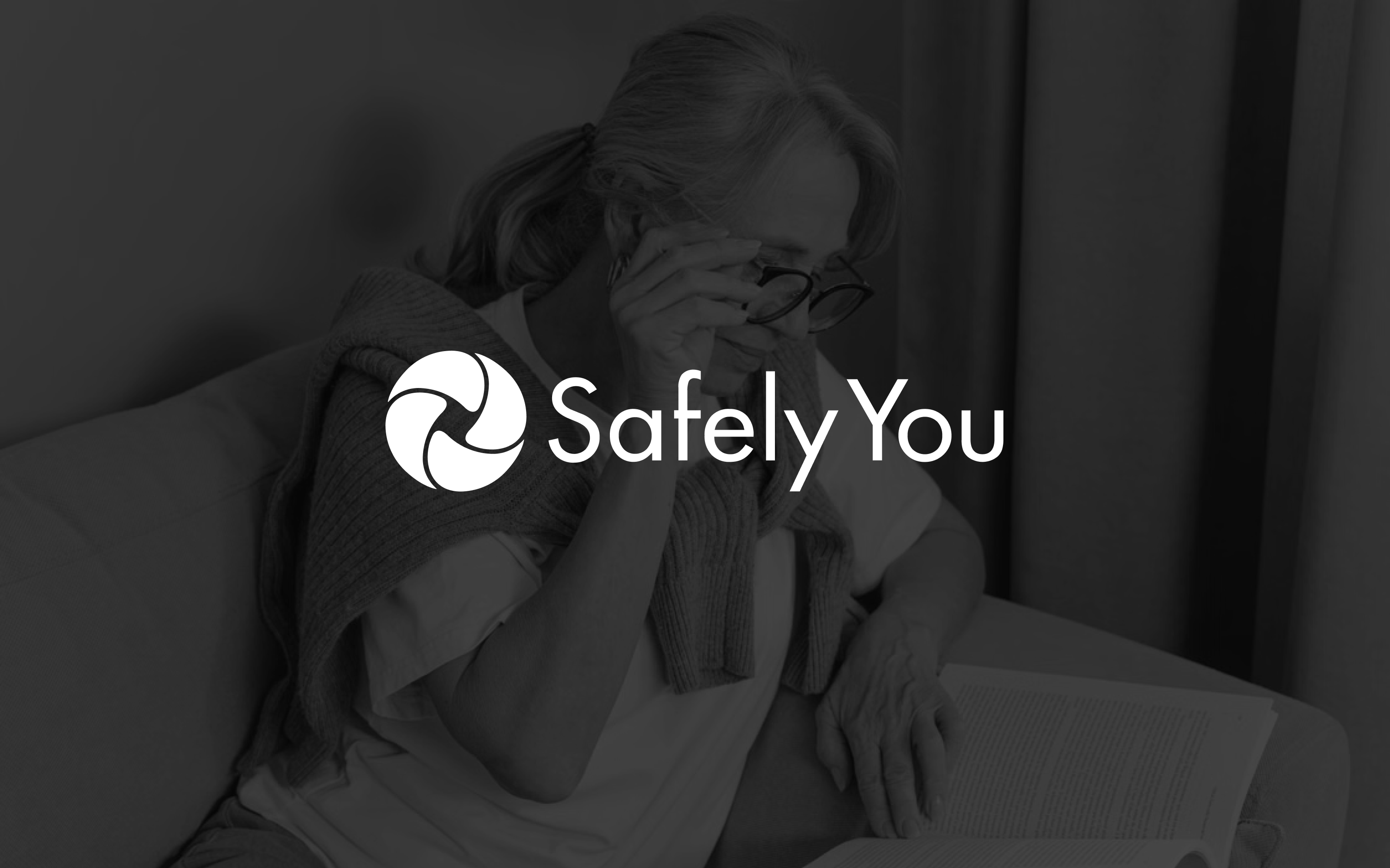 SafelyYou logo over a grayscale image of a woman reading. 