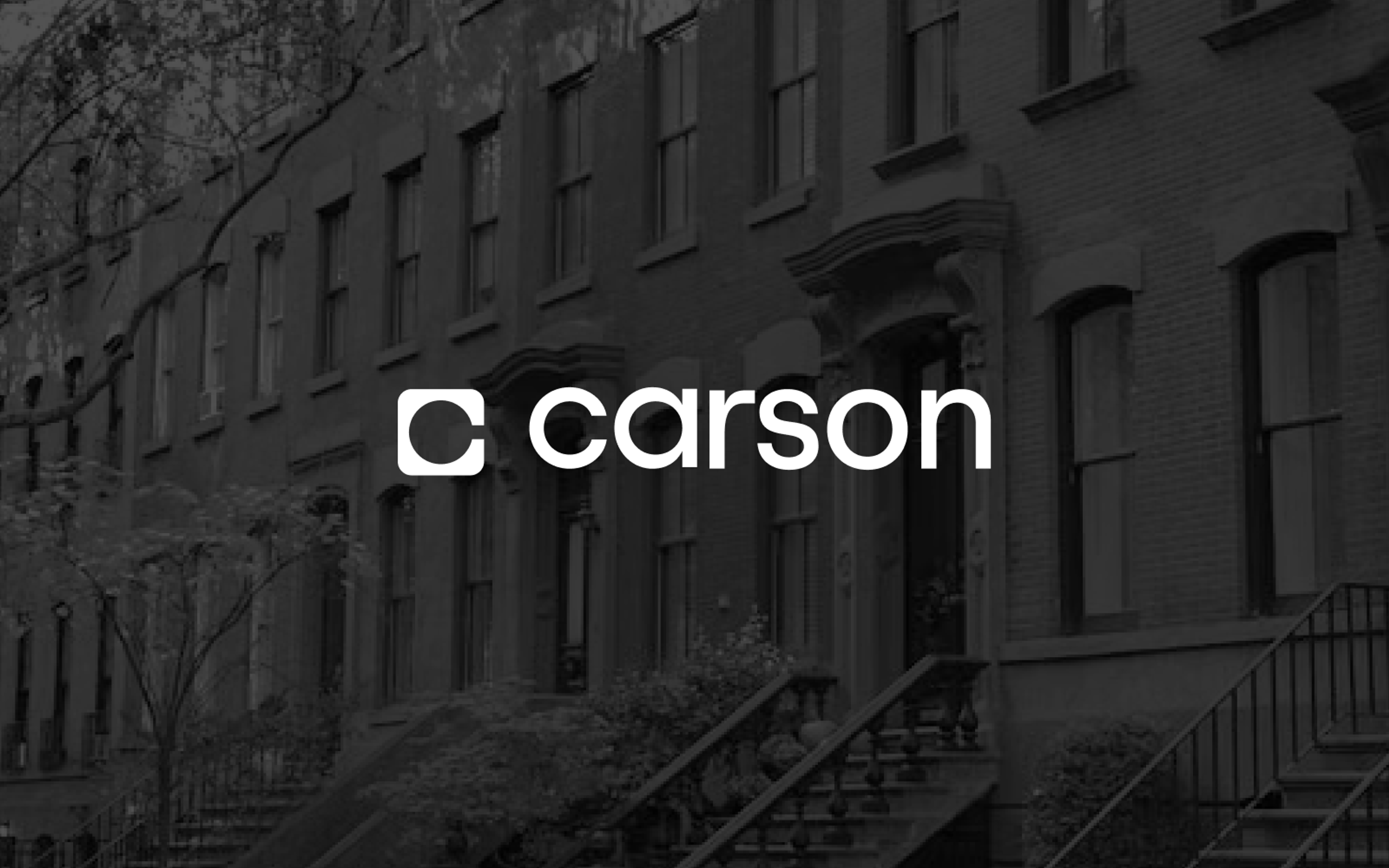 White Carson logo overlaid on a grayscale photo of brownstone buildings.
