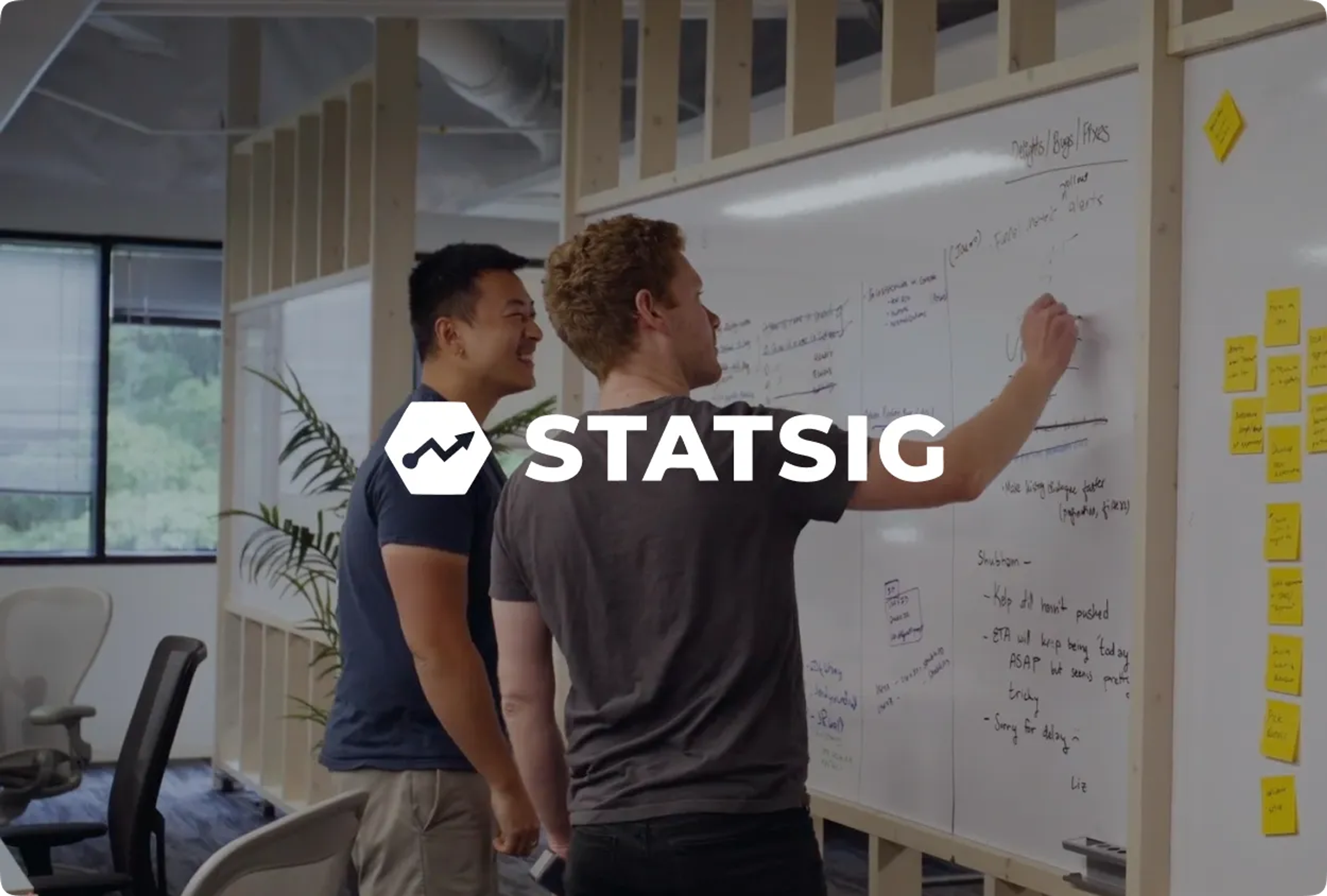 STATSIG logo with a growth icon overlaid on two men working at a whiteboard.