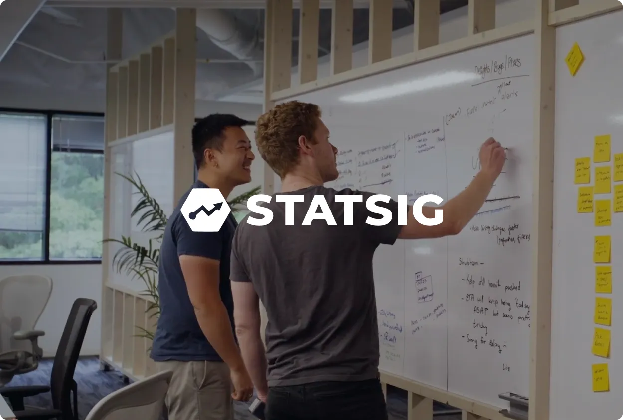 STATSIG logo with a growth icon overlaid on two men working at a whiteboard.