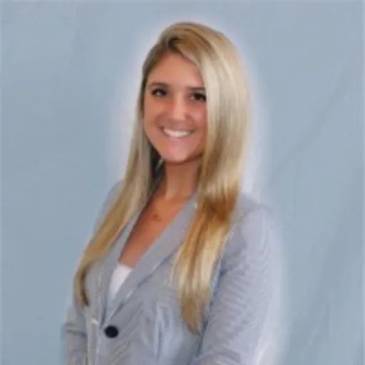A smiling young woman with long blonde hair wearing a striped blazer.