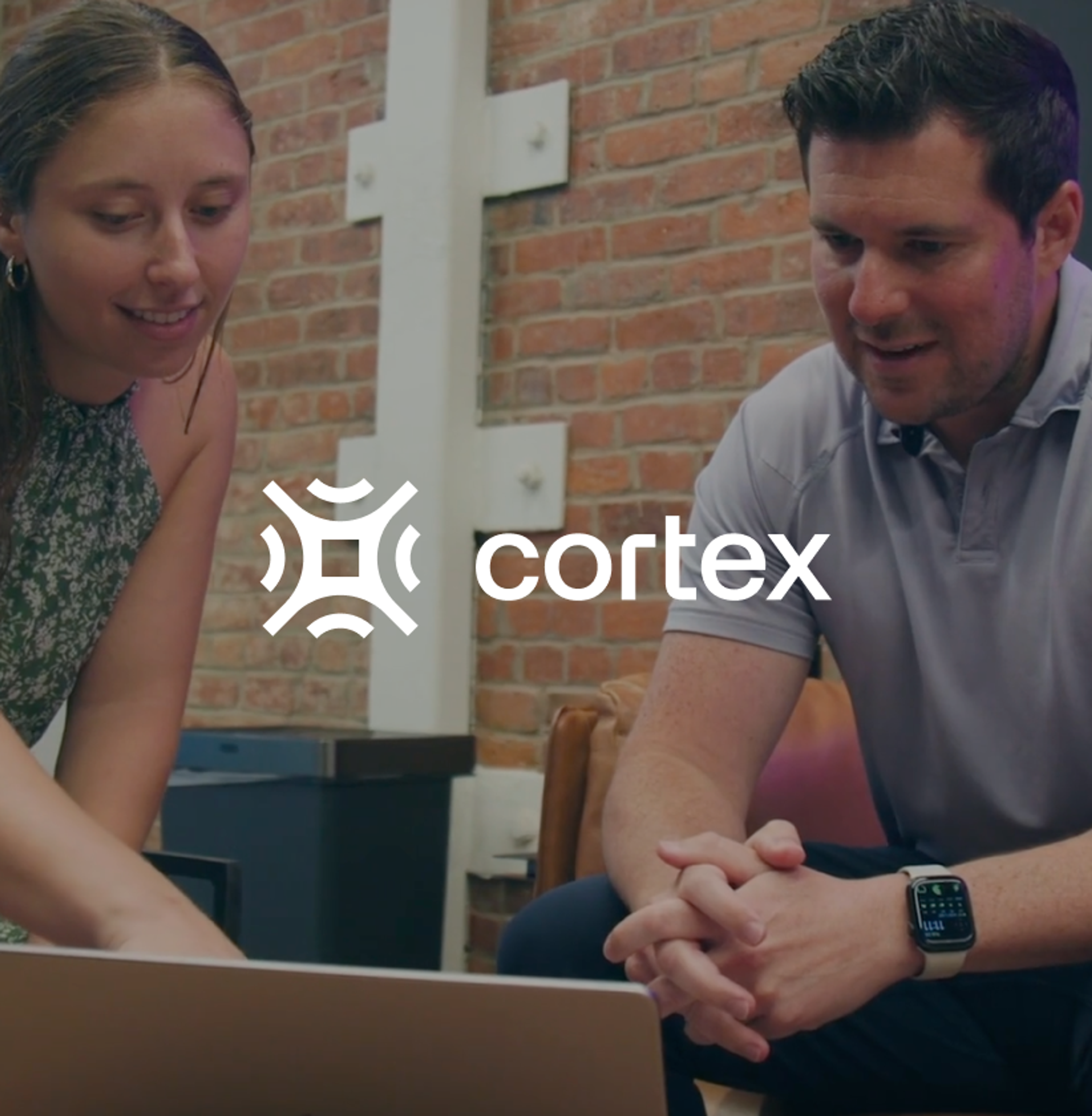 A man and woman looking at a laptop, with the Cortex logo superimposed.