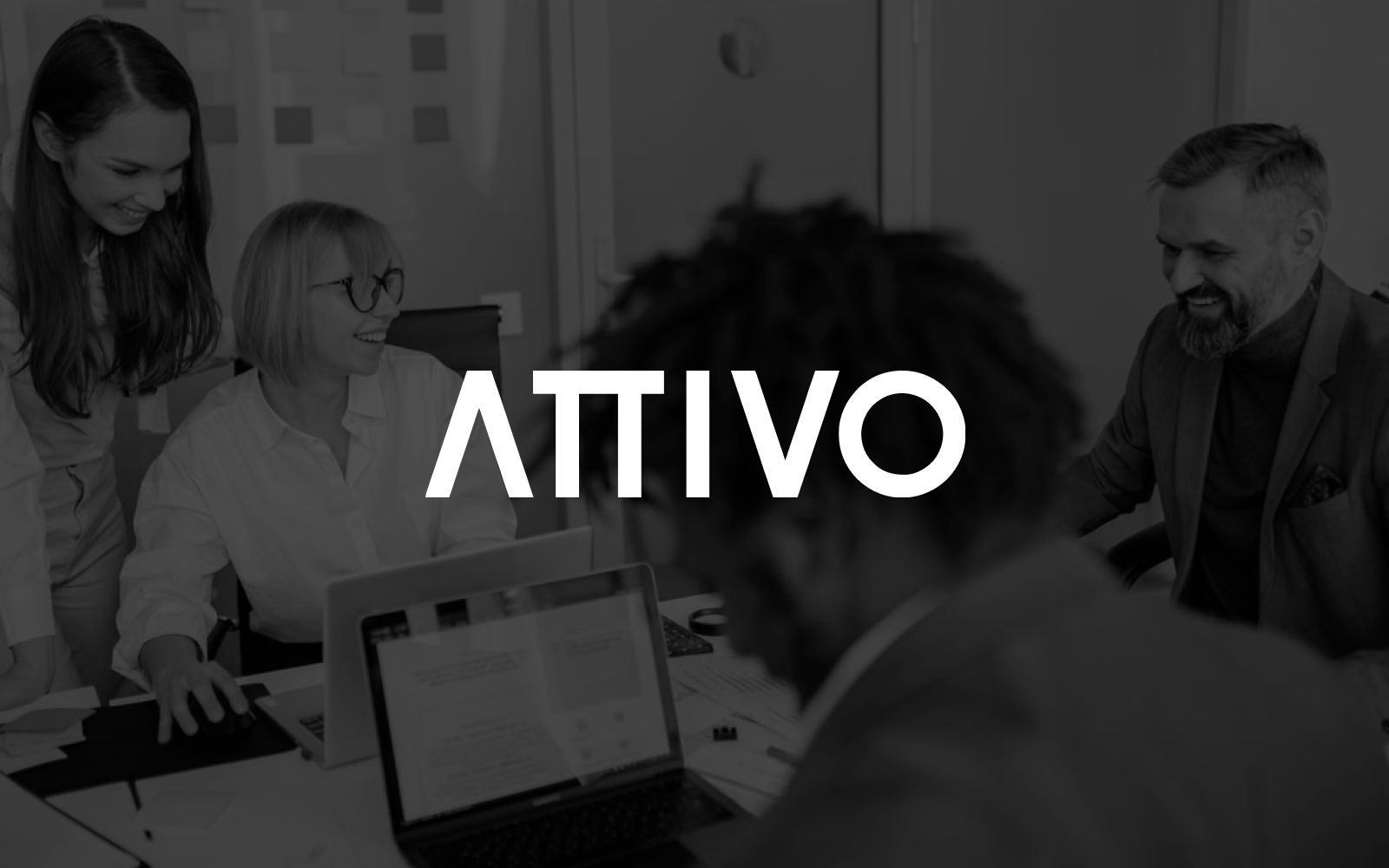 Grayscale image of four smiling people in an office looking at laptops, with the word 'ATTIVO' in white text overlaid.