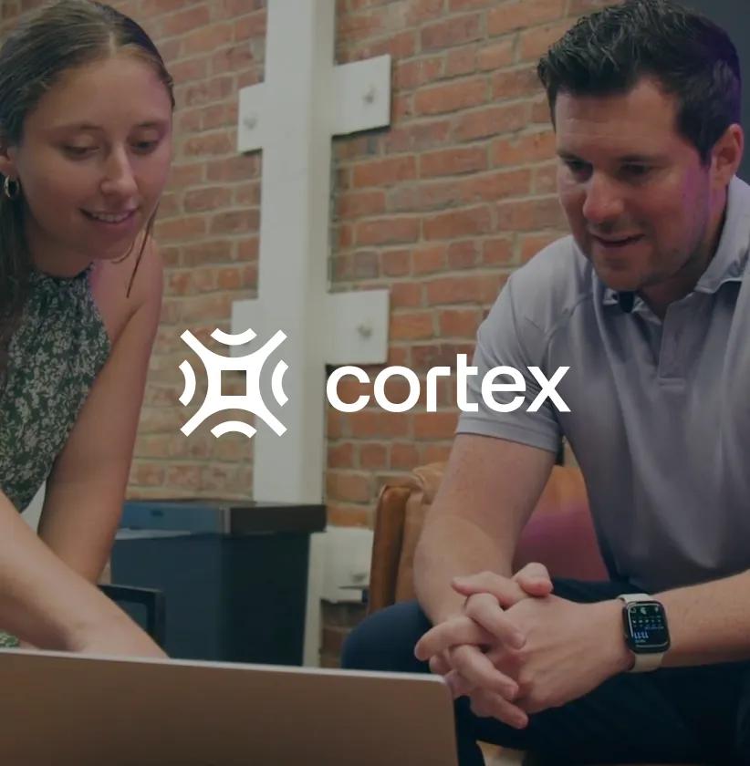 A man and woman looking at a laptop, with the Cortex logo superimposed.