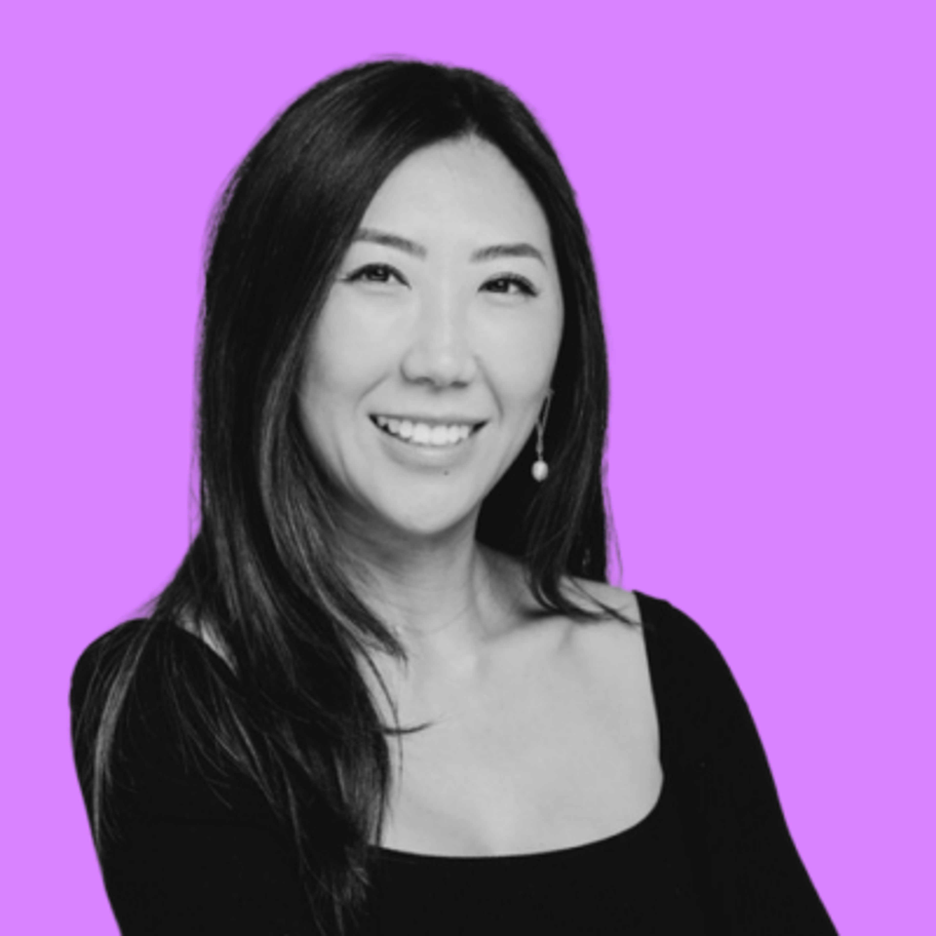 A smiling woman in black and white against a purple background.
