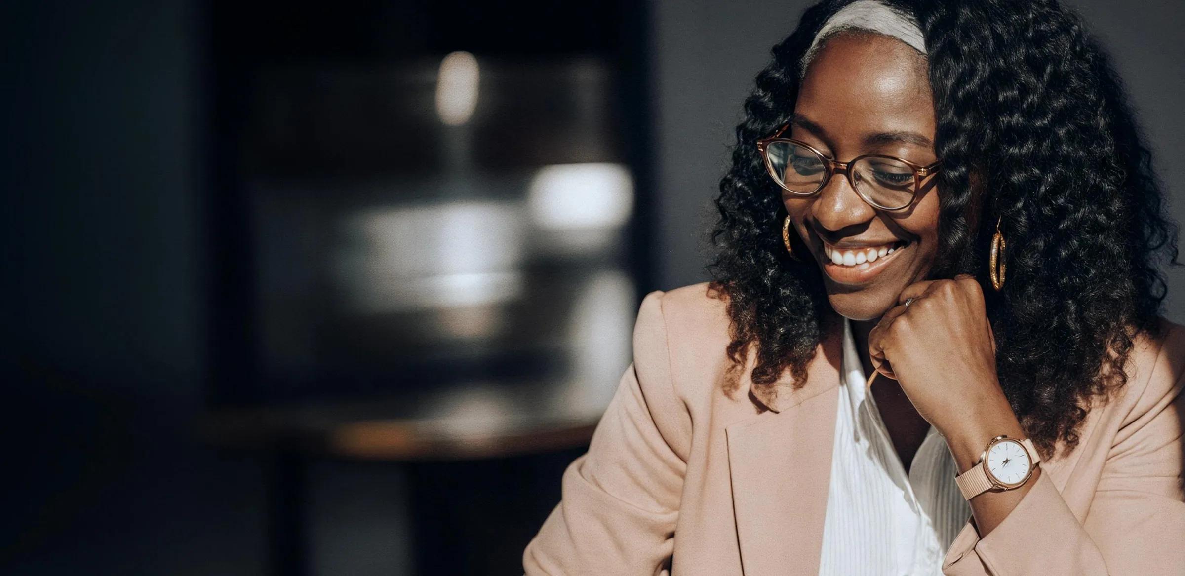 A smiling Black woman in glasses looks down, with two floating digital notifications next to her for "New invoice created!" and "Invoice #1234 sent".