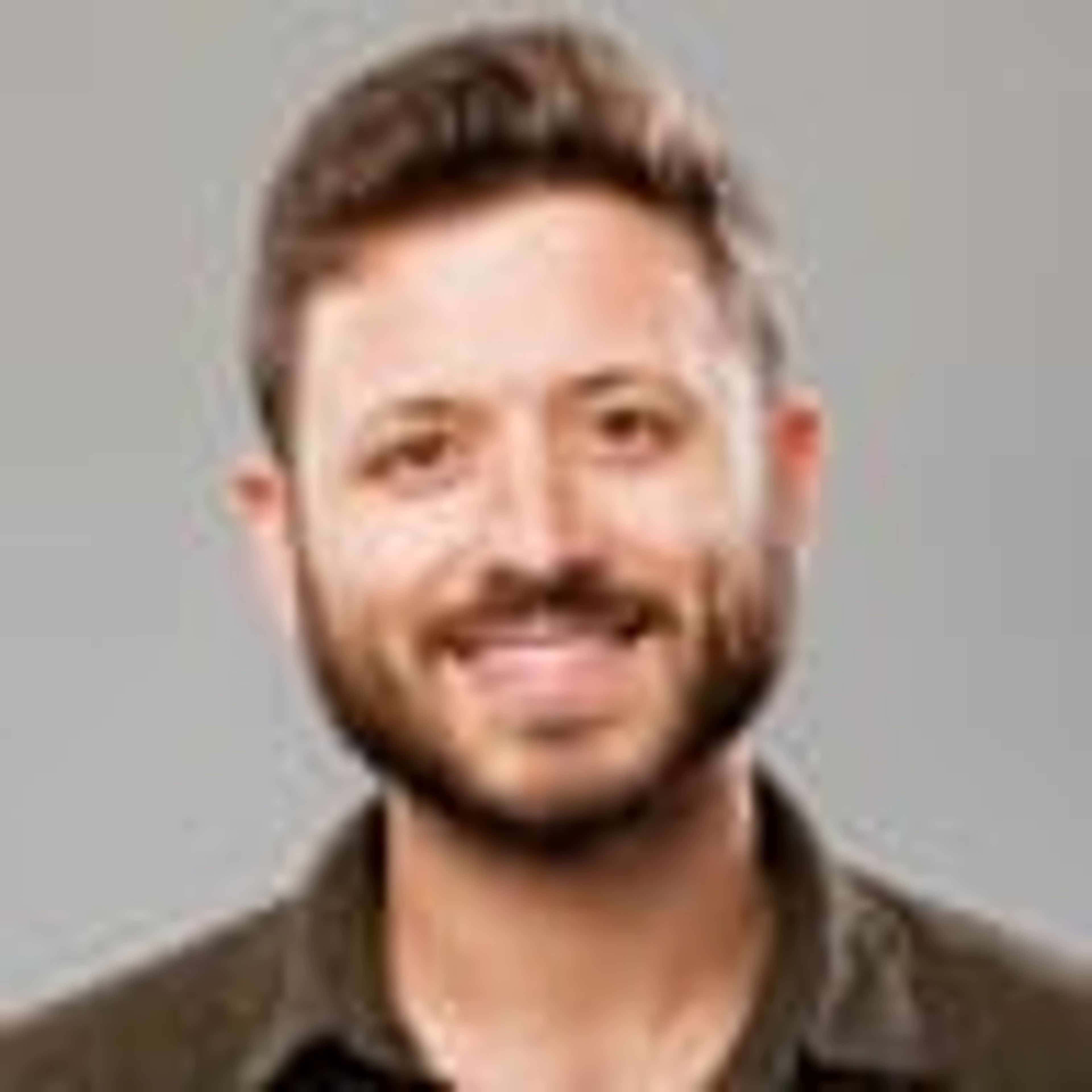 Smiling man with a beard.