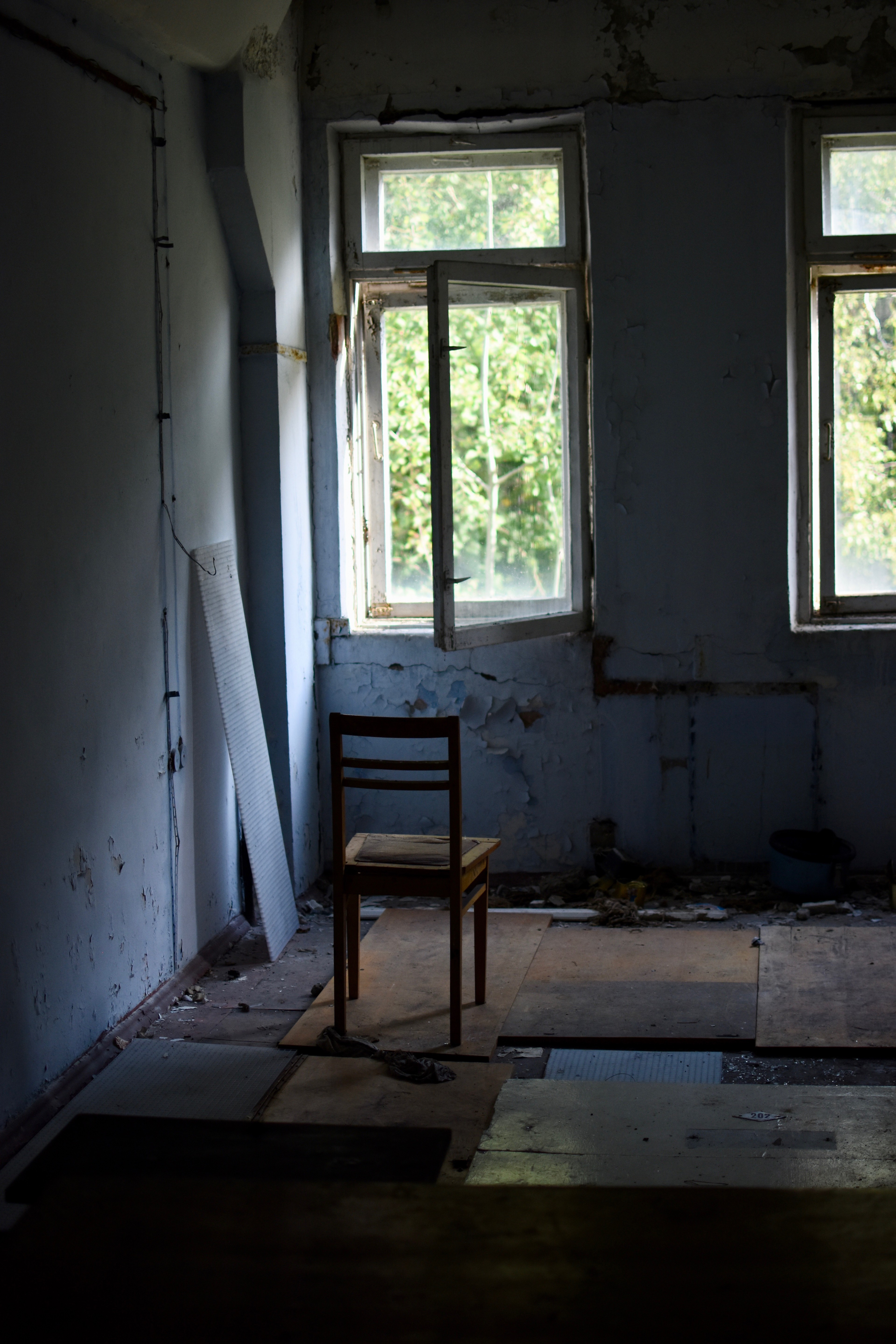 A bare room with a chair beside a window.