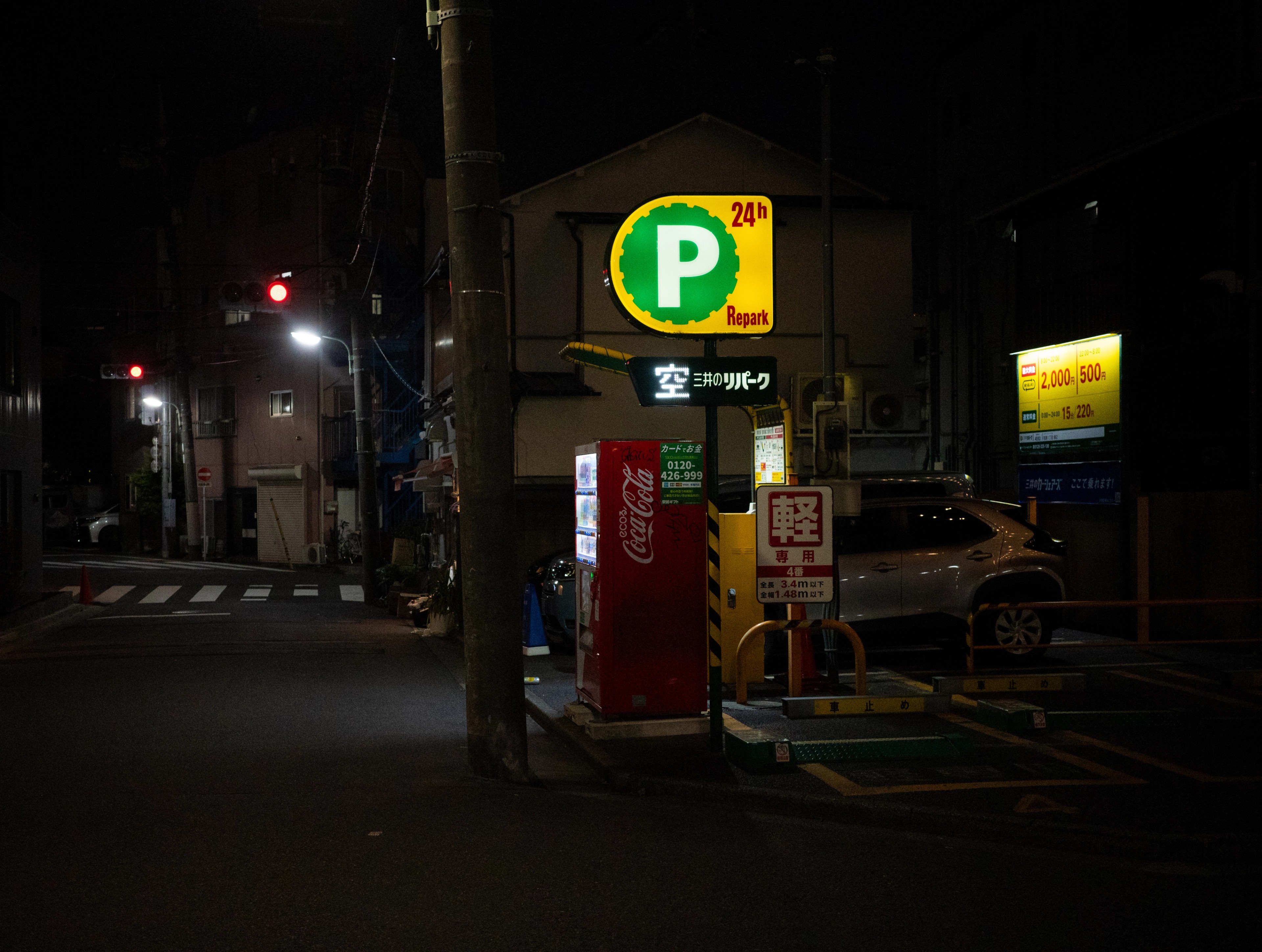 Parking signs glow beside an empty night street.