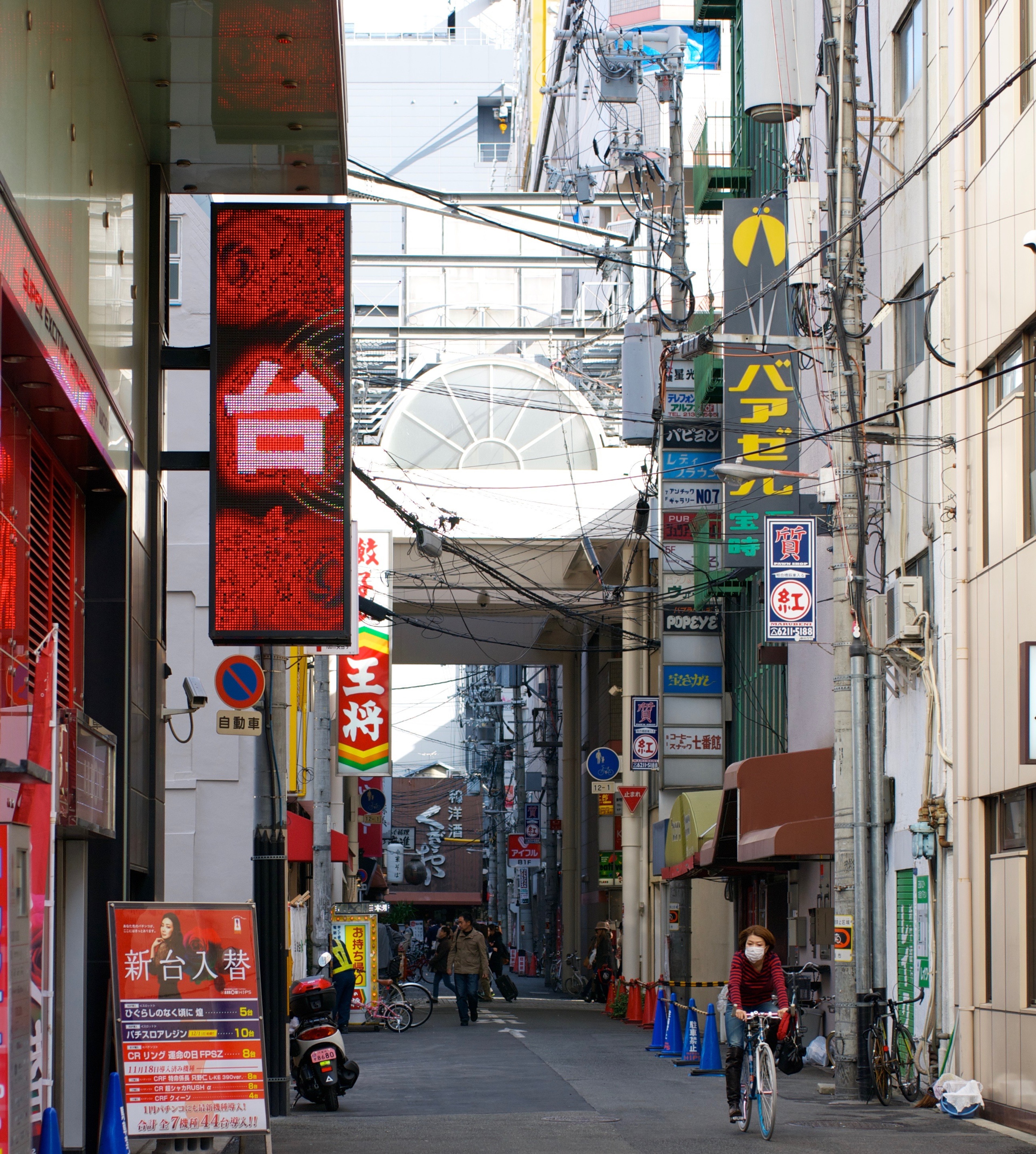 Vertical Japanese shop signs hang above a narrow street.
