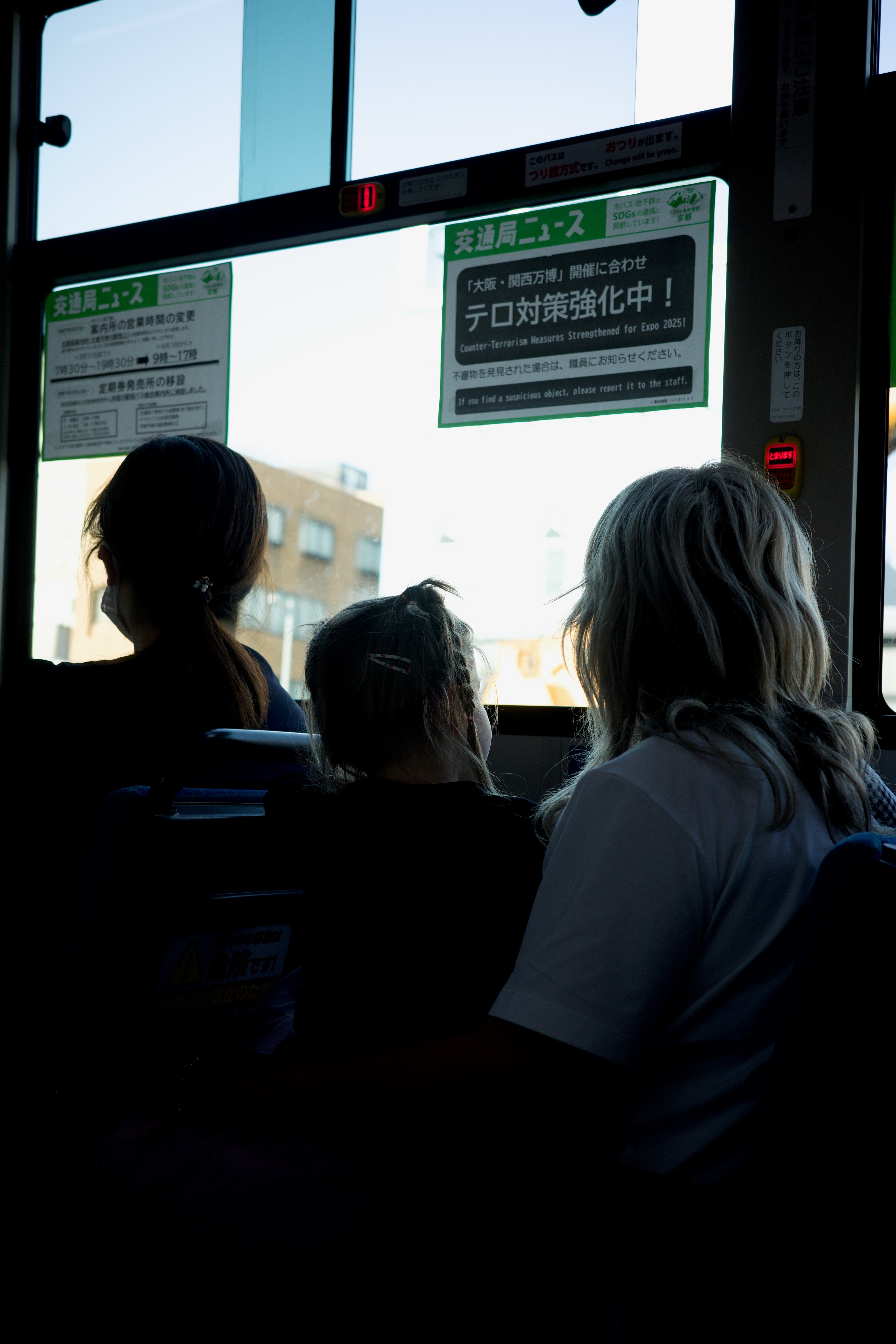 Passengers sit inside a train, silhouetted against station windows.
