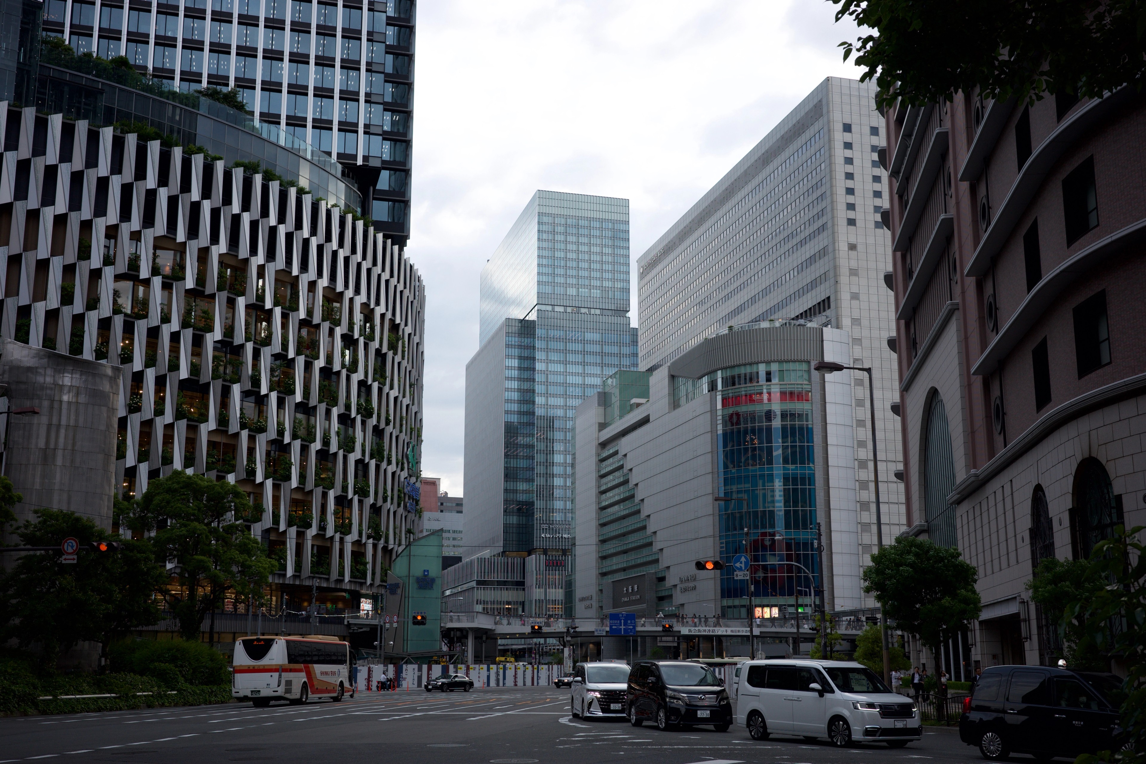 Glass office buildings rise along a broad city street.