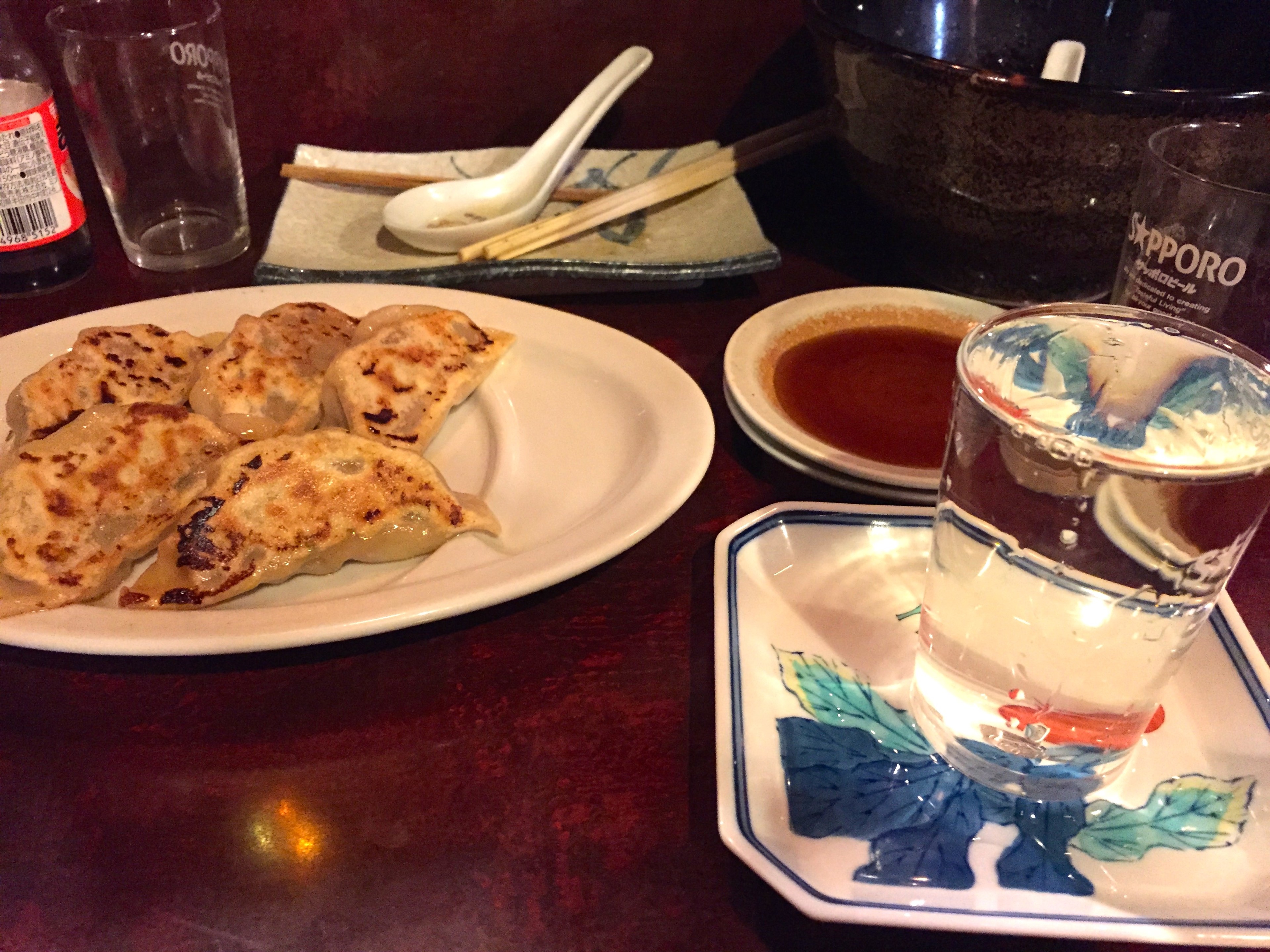 Plates of food and drinks are arranged on a restaurant table.
