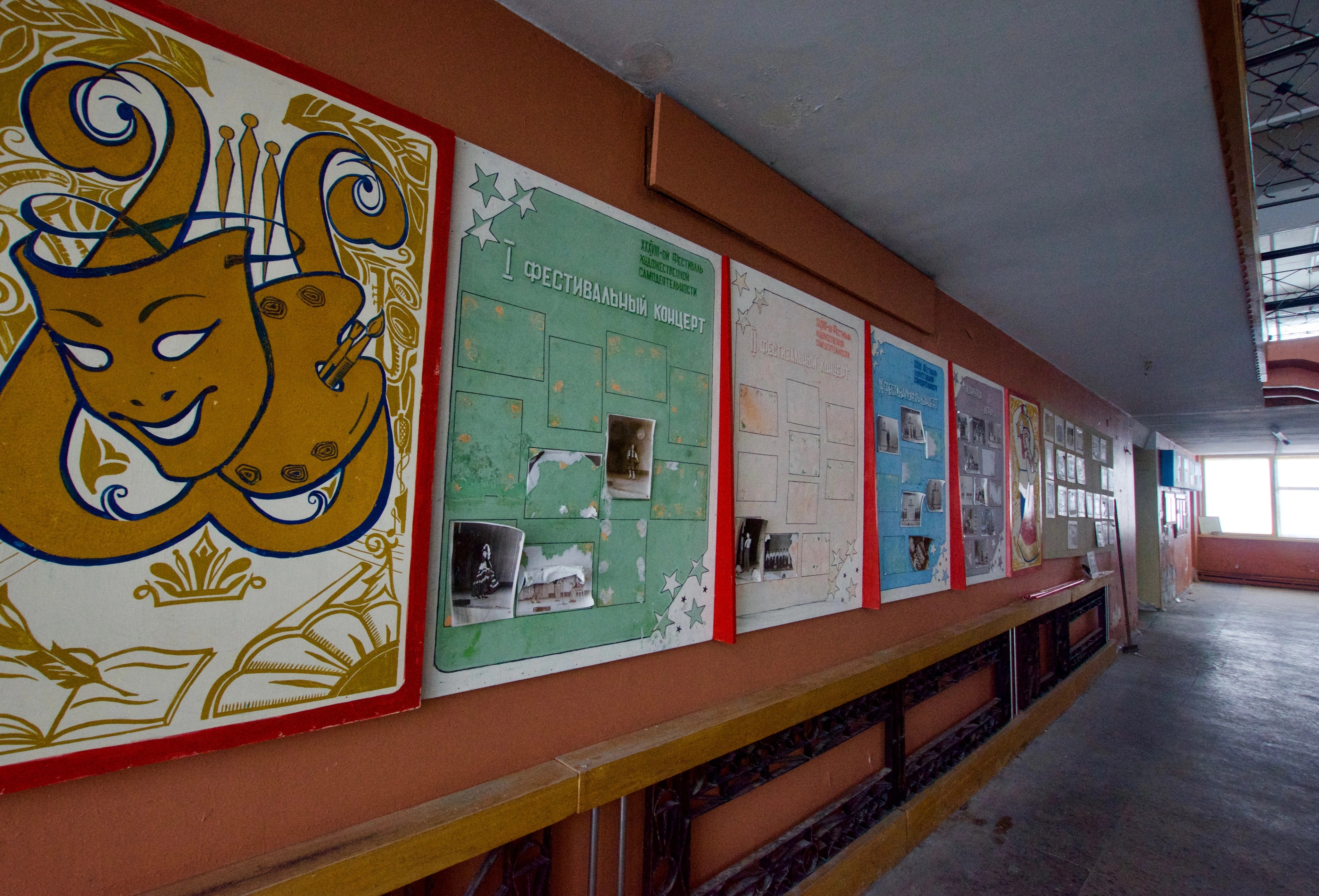 A corridor displays colorful wall panels and notices.