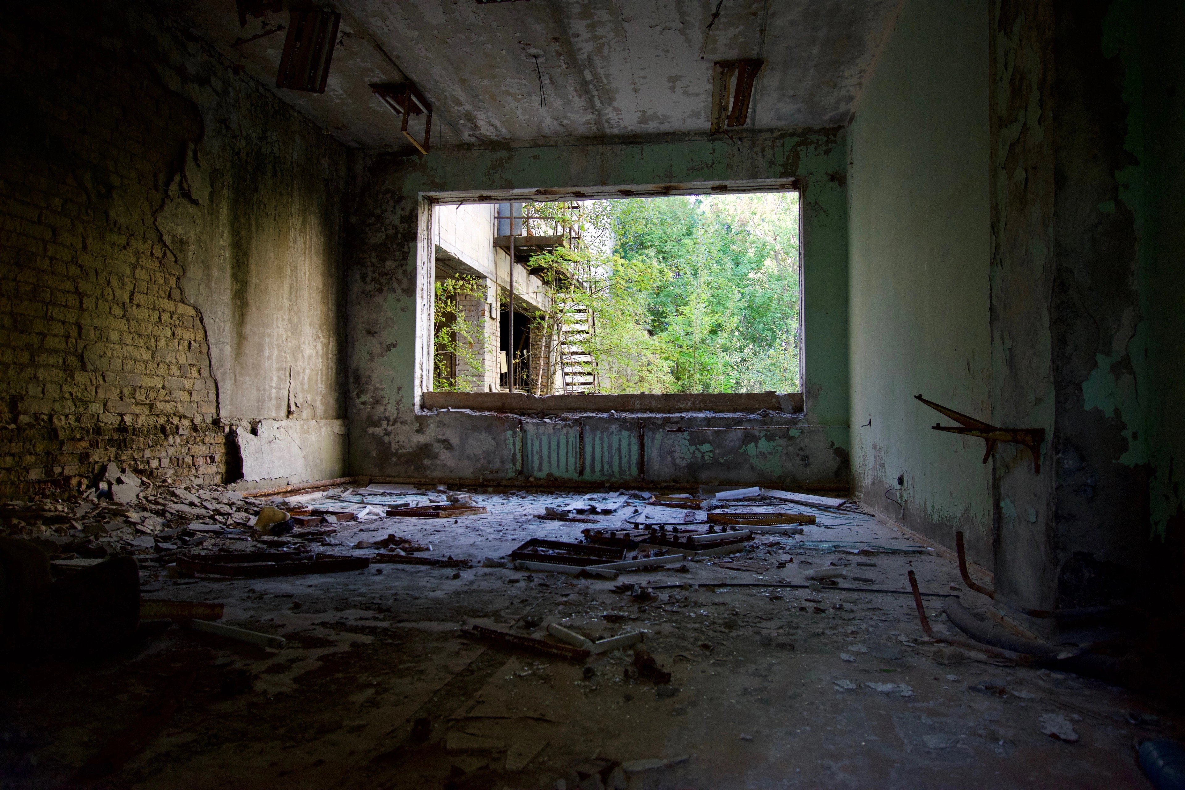 An empty room with broken windows and peeling walls.