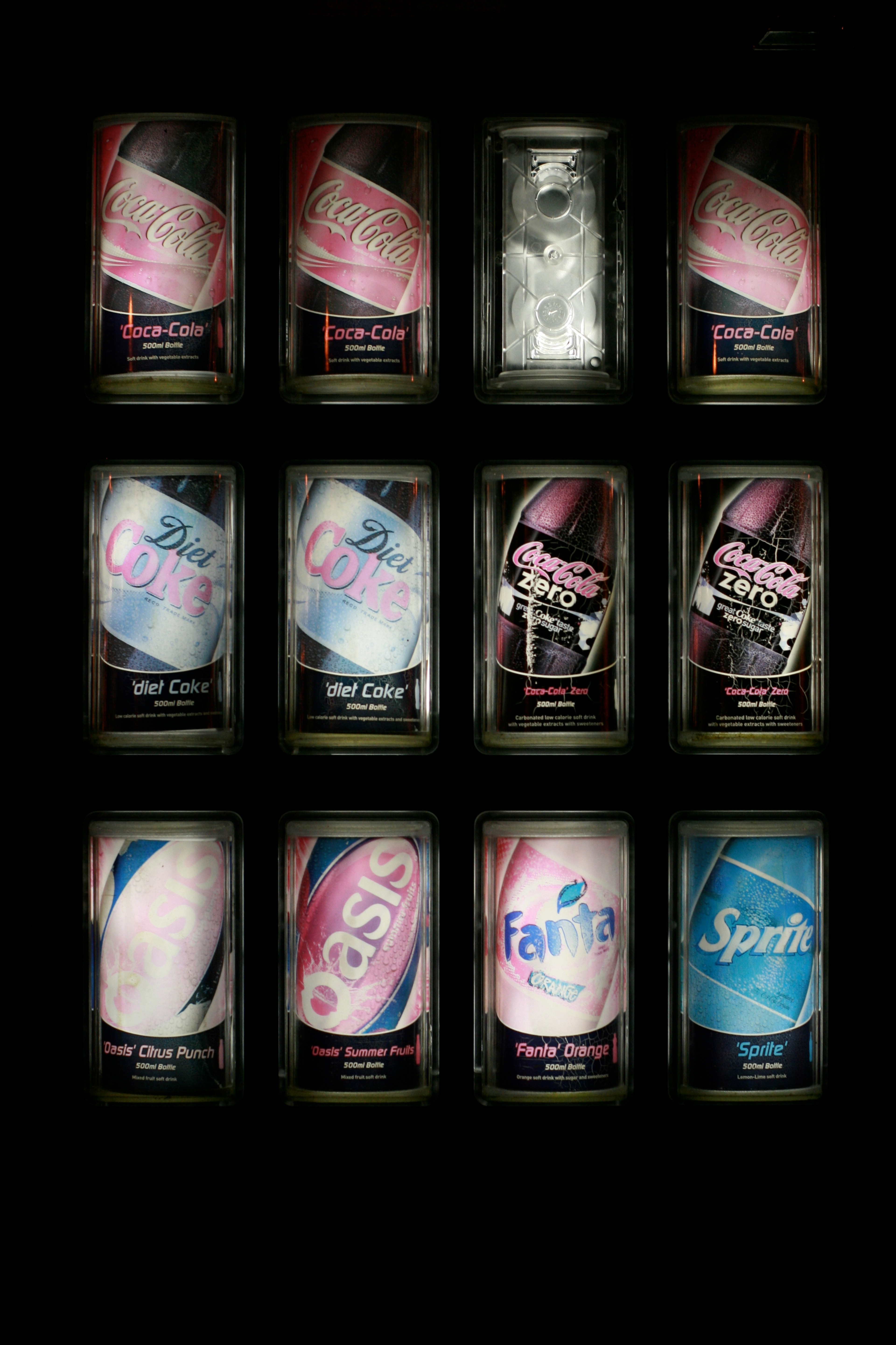 A grid of small illuminated images hangs on a dark wall.