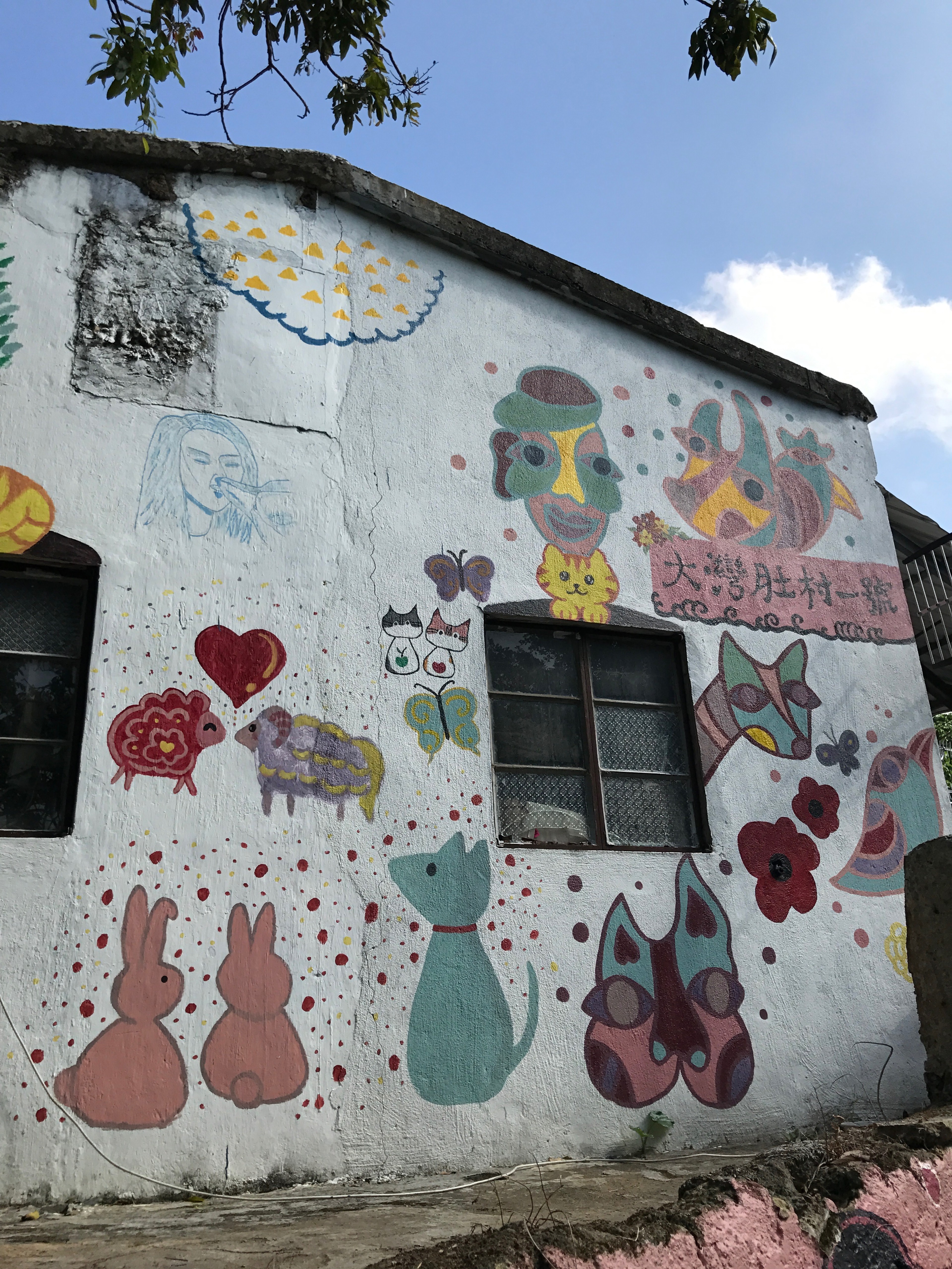 A painted wall features colorful cat figures and other playful shapes.