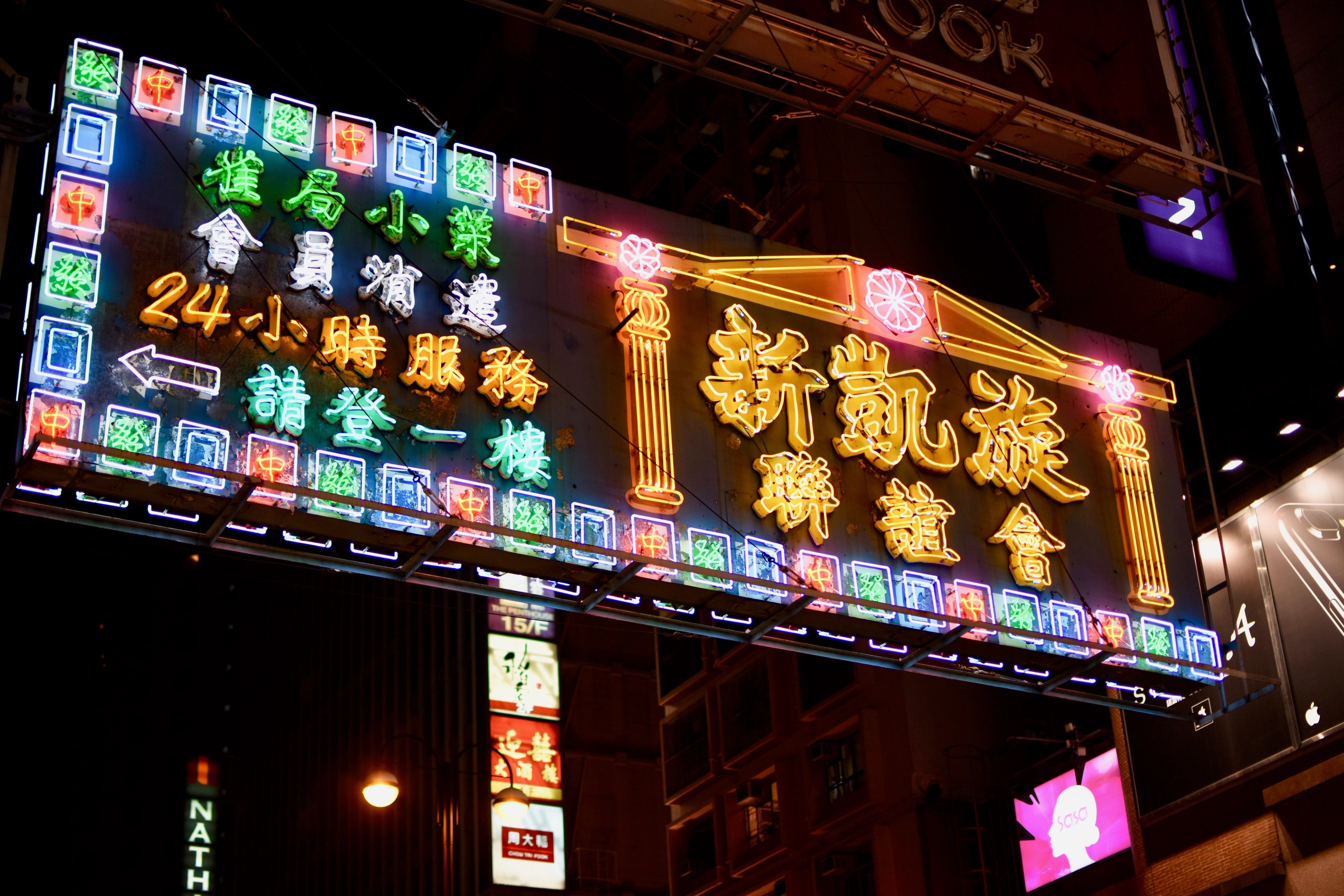 Large Chinese-language neon signs glow above a night street.