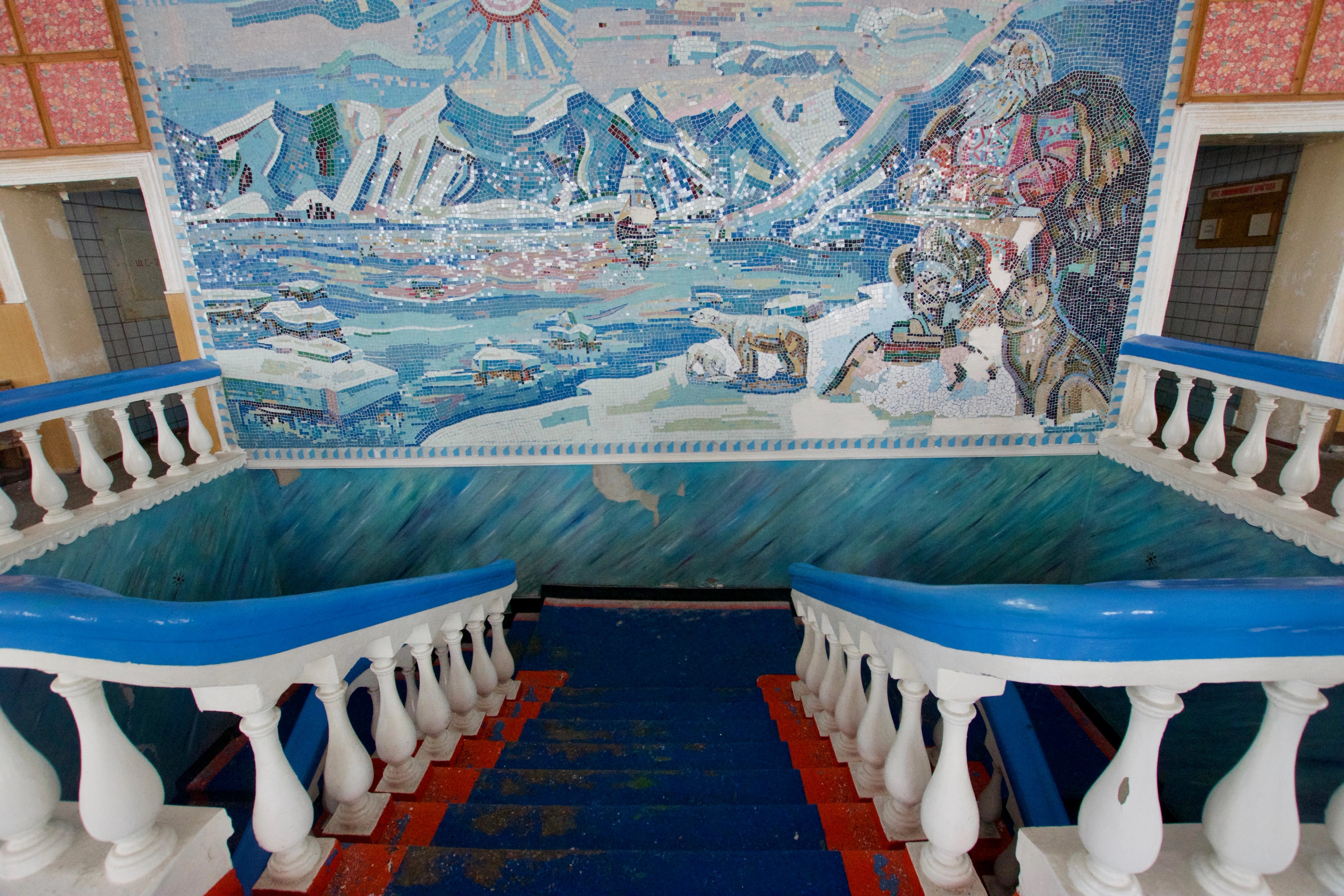 A painted mural decorates a broad interior stairwell.