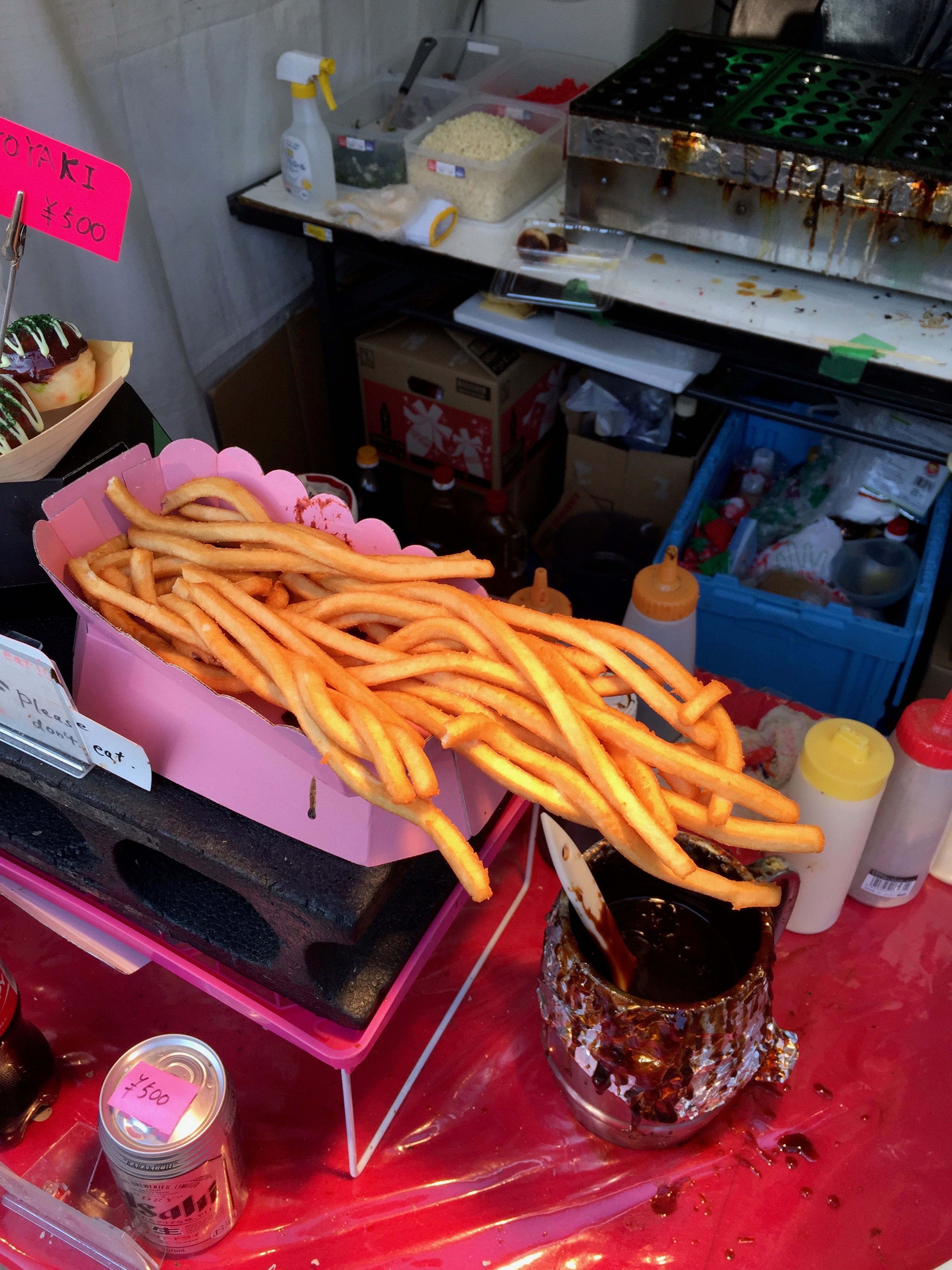 A bright orange drink and a plate of skewers sit on a small table.