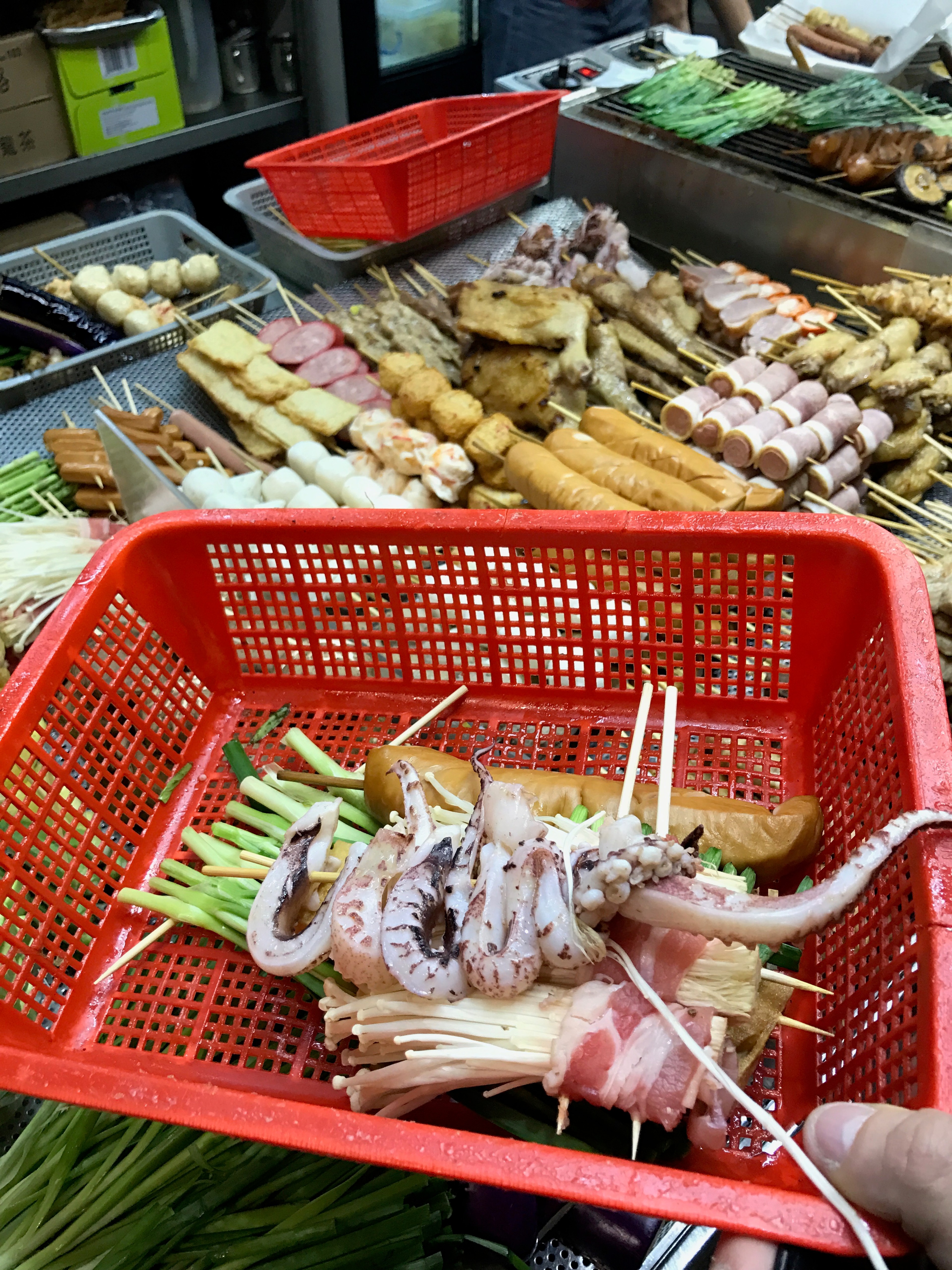 A red basket displays fresh seafood at a market stall.