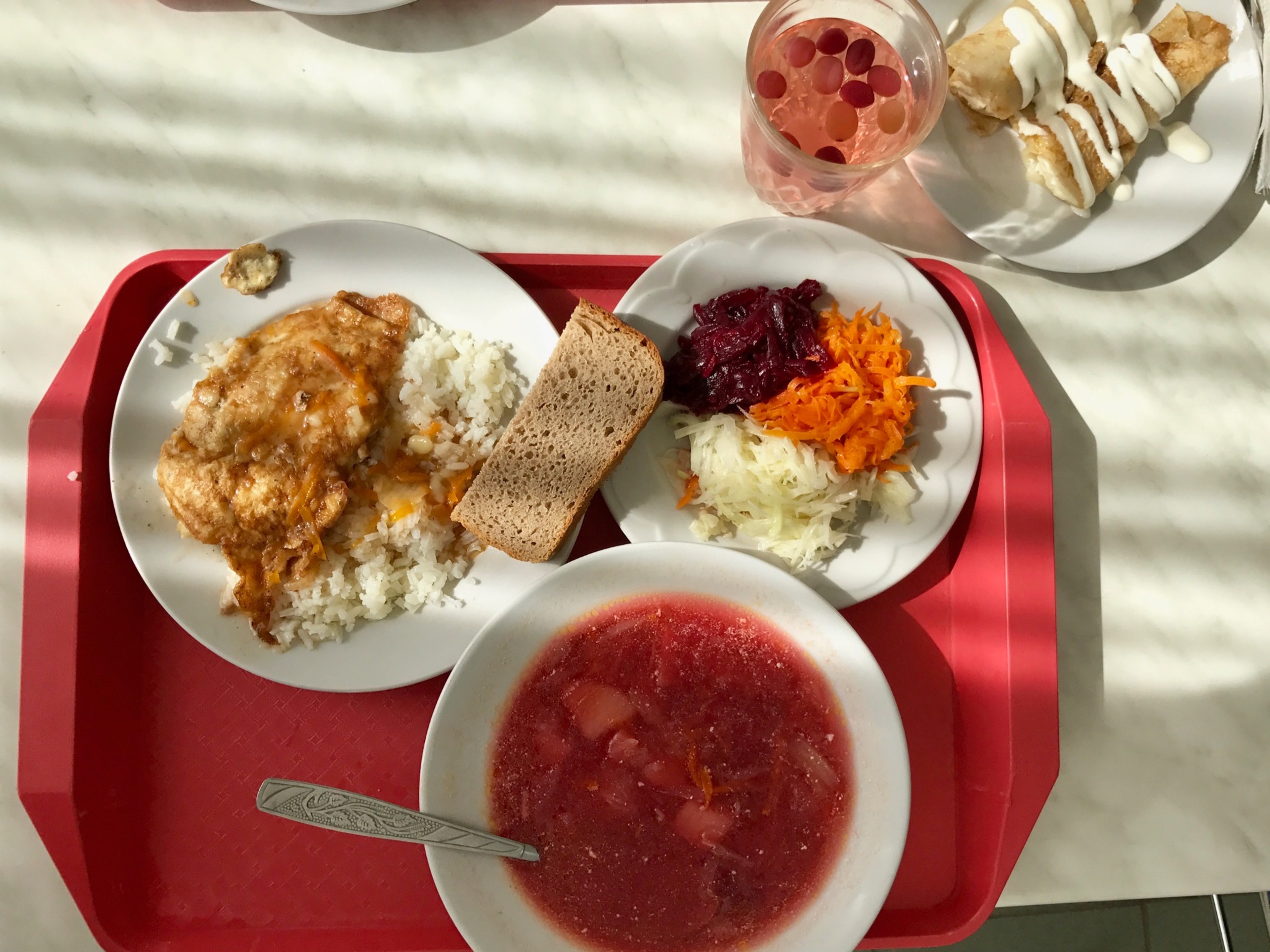 A cafeteria tray with several dishes sits on a table.