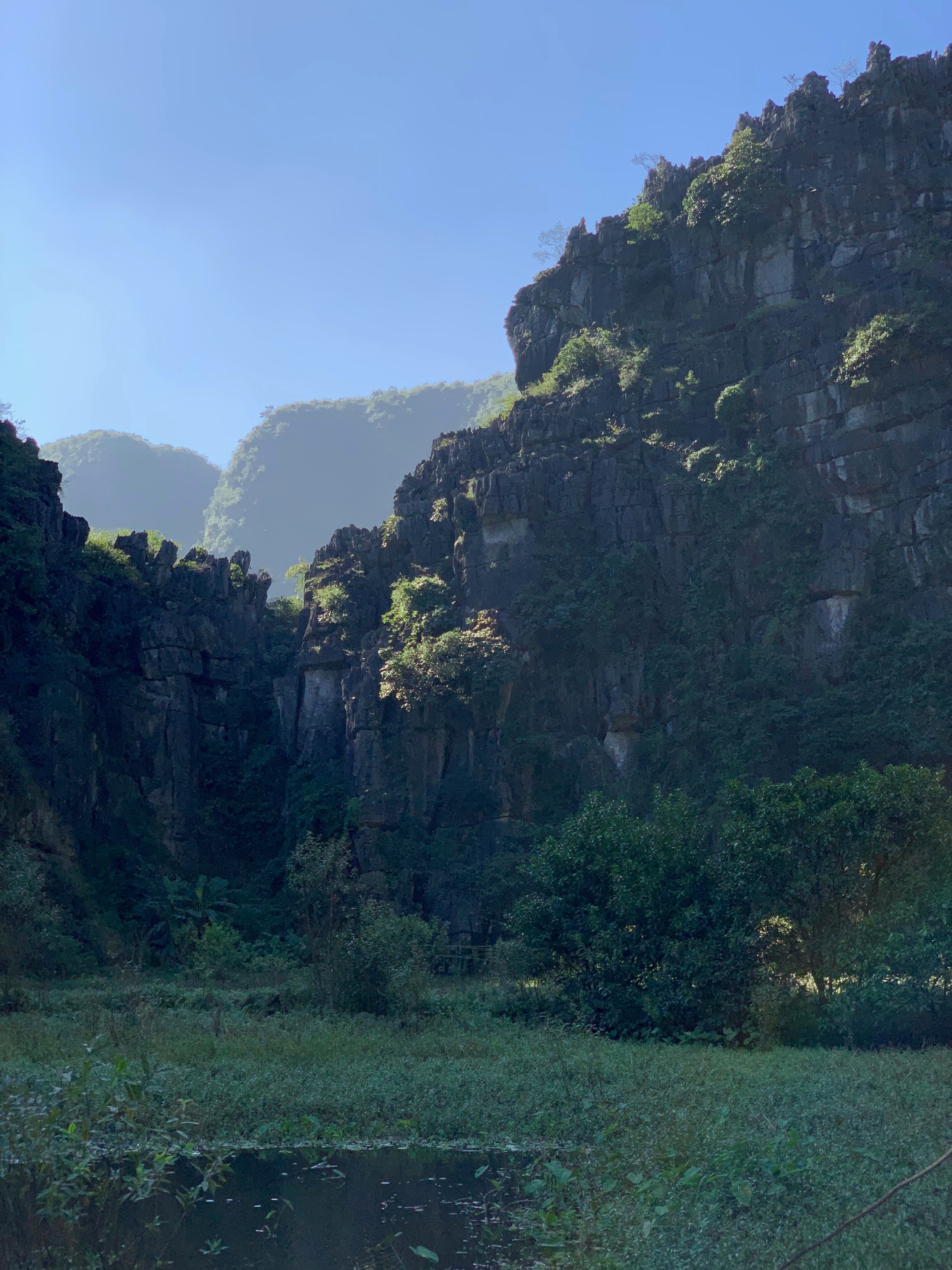 A narrow river runs between forested limestone cliffs.