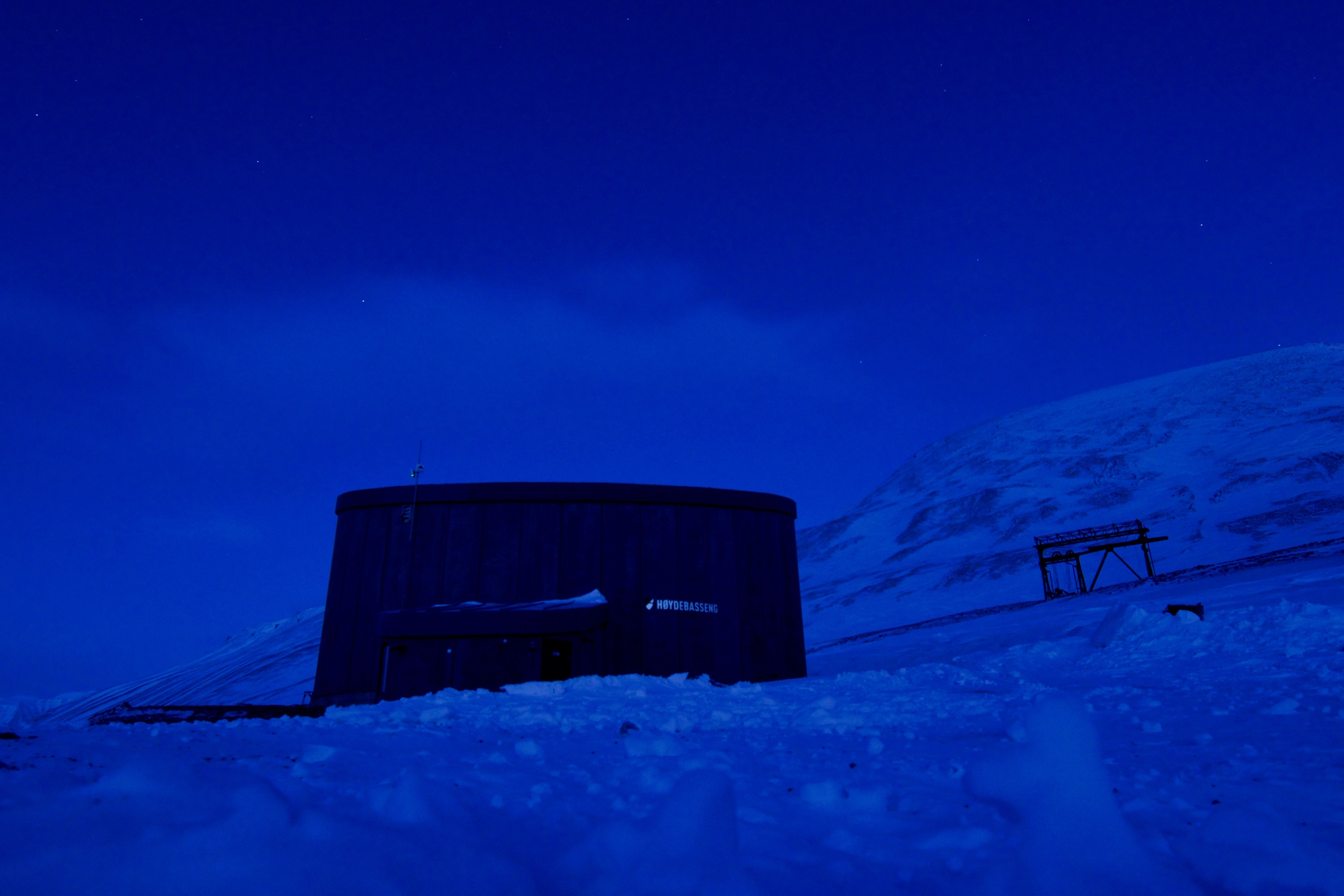A low building sits beneath a deep blue twilight sky.